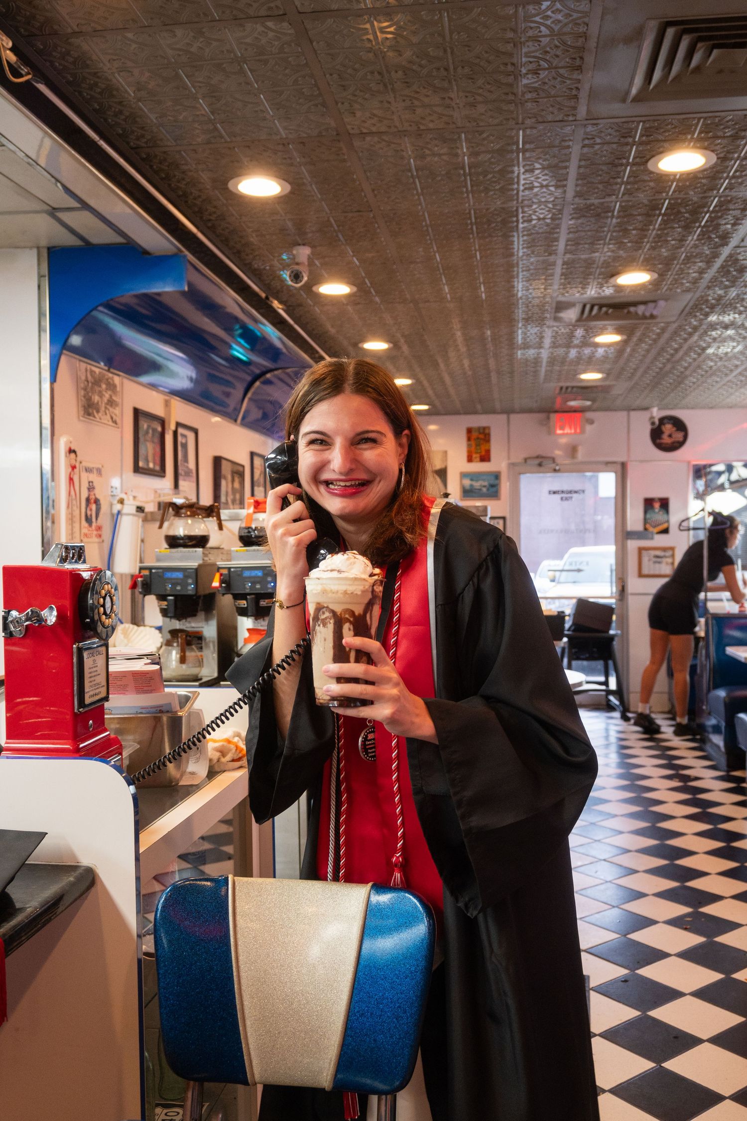 Series of graduation photos taken in a retro diner with checkered floor.