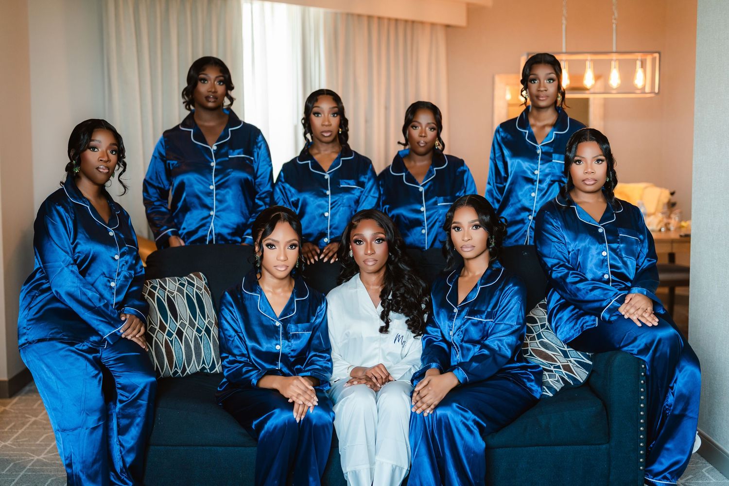 Wedding party members in royal blue satin robes relax together during pre-ceremony preparations.