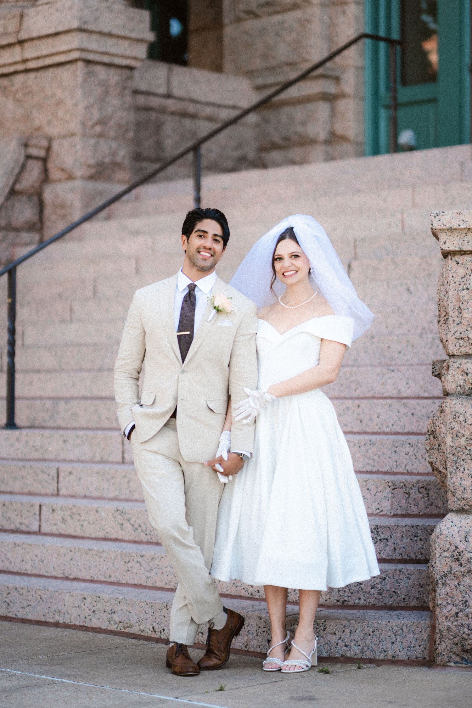 A series of romantic wedding photos showing a couple sitting and posing on stone steps of a historic building.