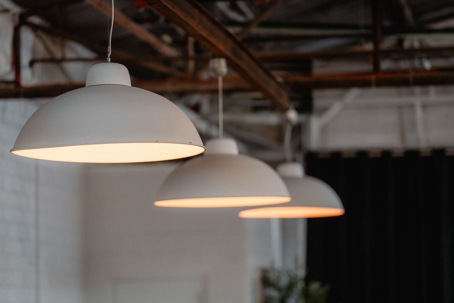 Modern industrial wedding venue with pendant lights hanging from exposed ceiling.