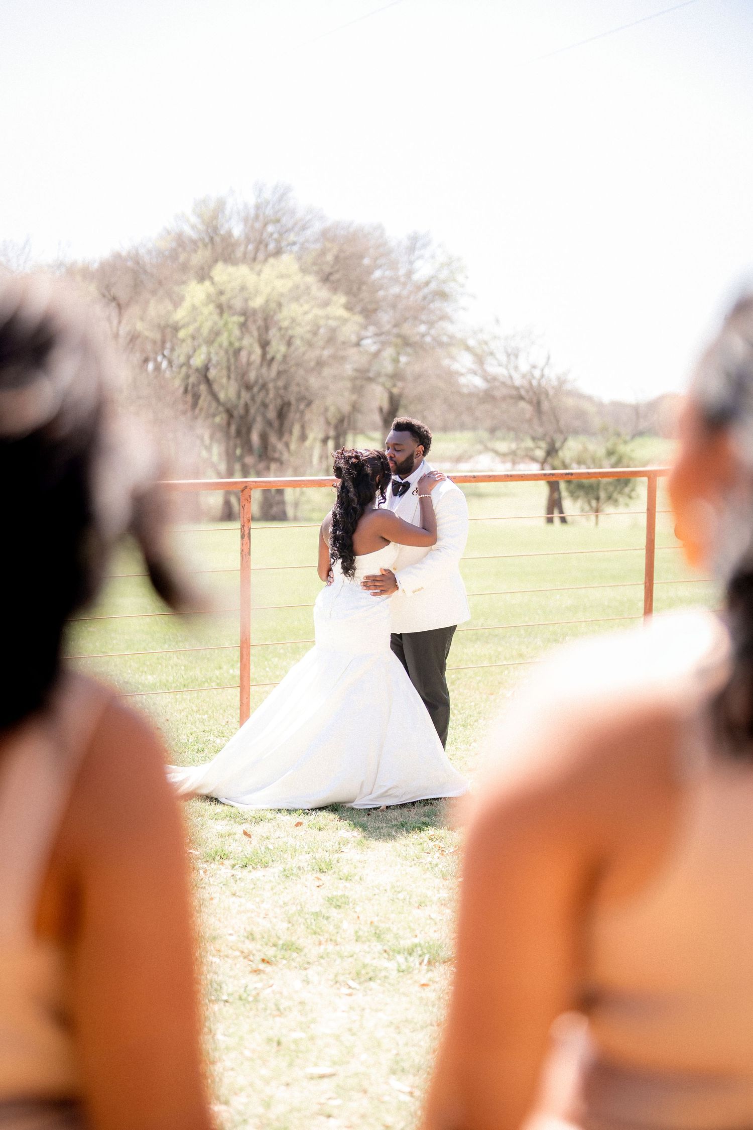 Wedding guests watch as a couple shares a playful moment during their outdoor ceremony.