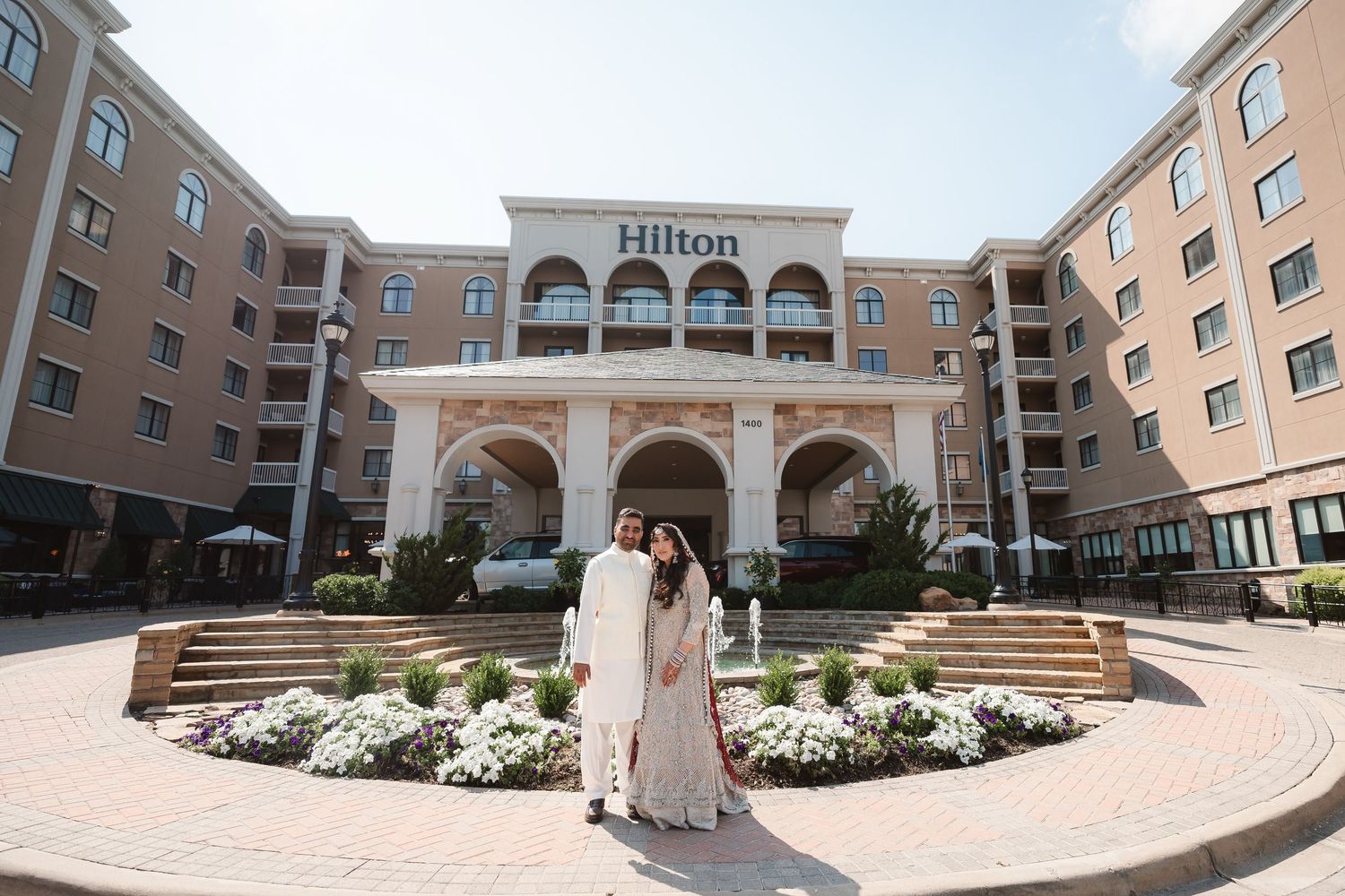 Panoramic view of a Hilton hotel exterior with brick facade and arched windows.