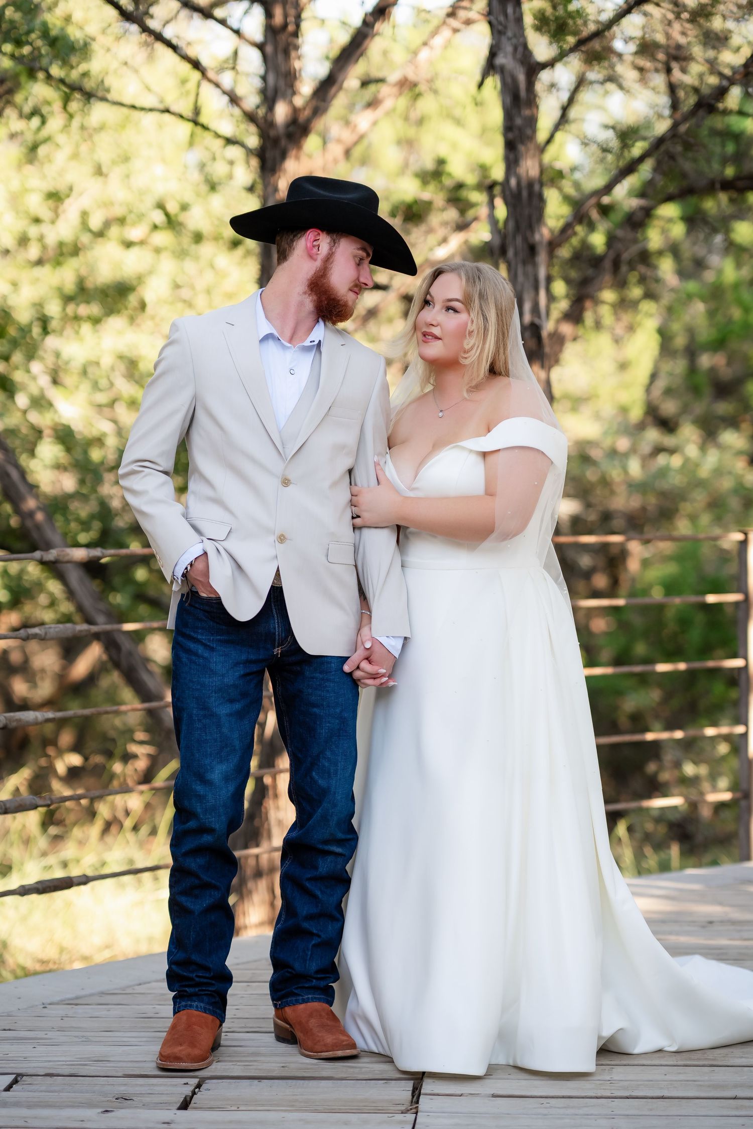 A couple shares intimate moments on a wooden deck during their wedding photoshoot.