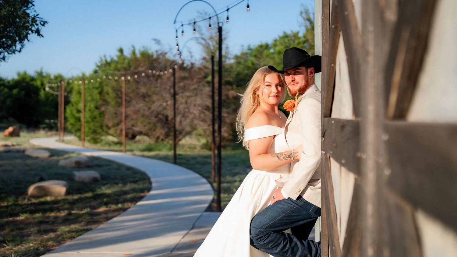 A romantic couple embrace against a wall during their outdoor wedding photo session.