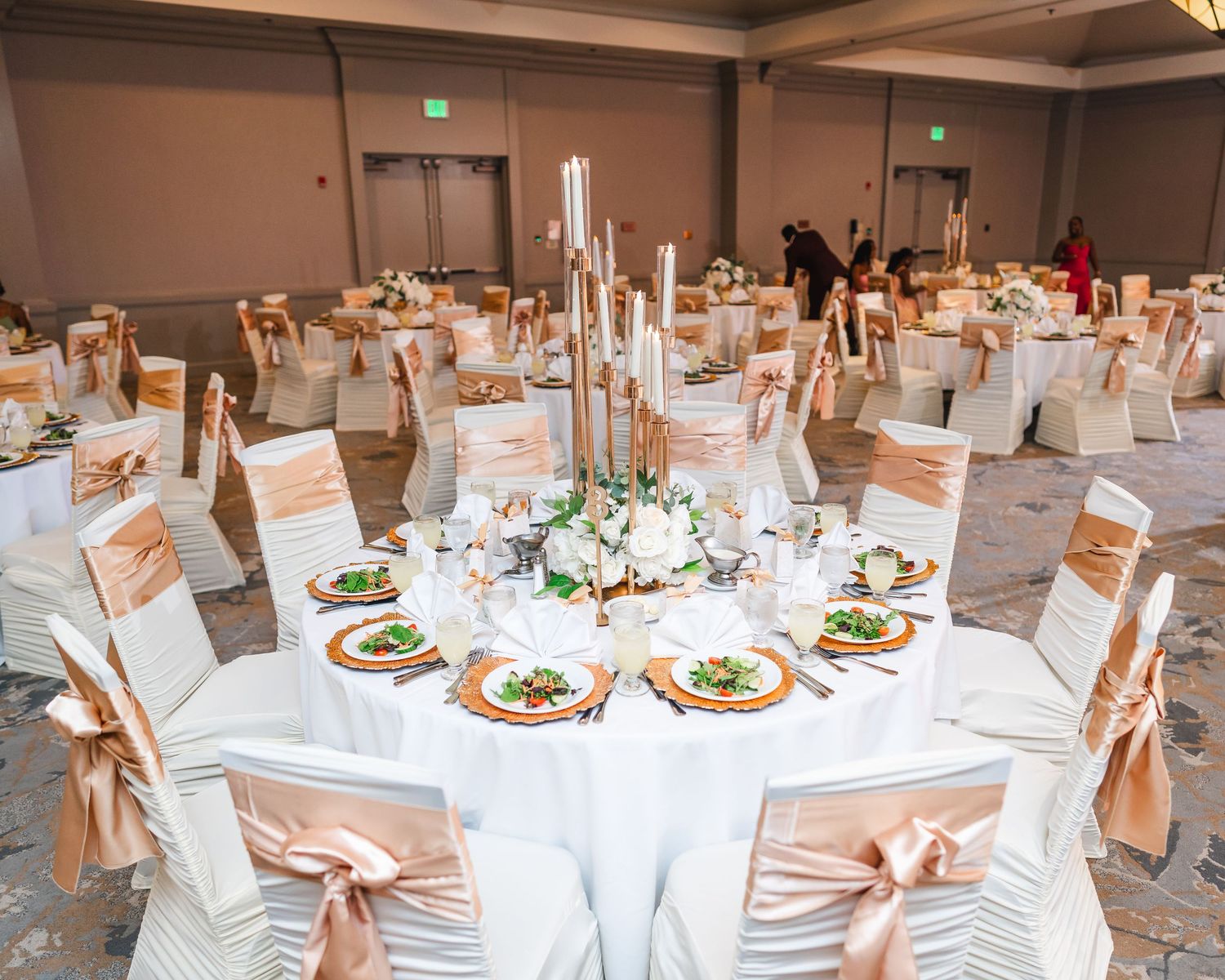 Elegant wedding reception venue with round tables decorated in white linens and floral centerpieces.
