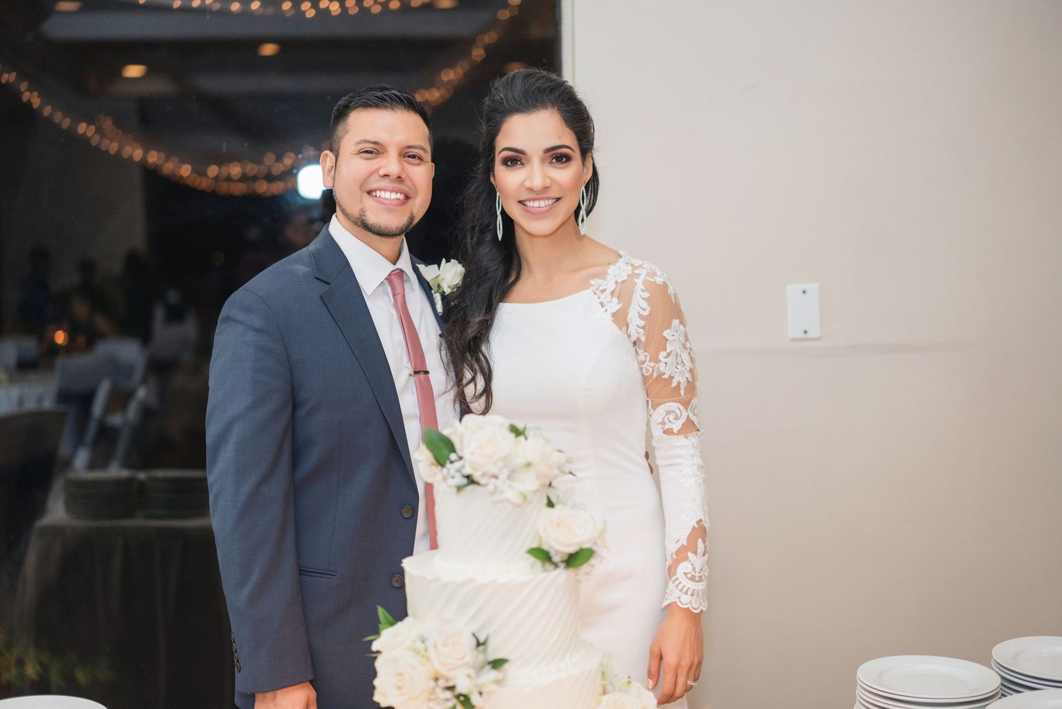 Wedding celebration in modern indoor venue with warm lighting and neutral decor.