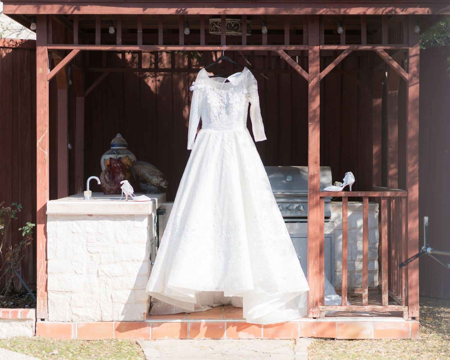 Wedding dress display under a rustic wooden pavilion with multiple gowns on mannequins.