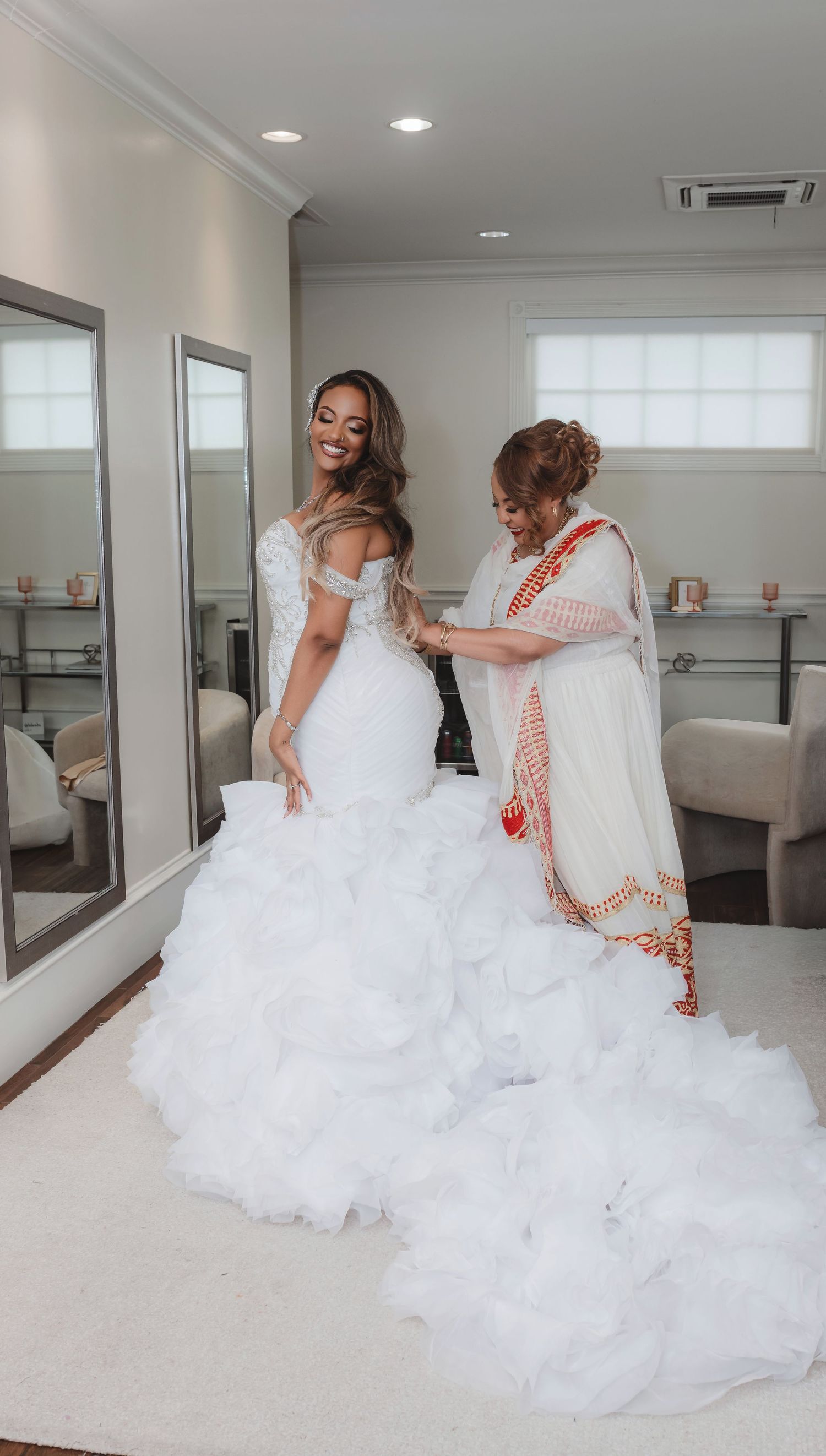 Elegant bride in voluminous white wedding gown twirling and dancing in a bright modern studio space.