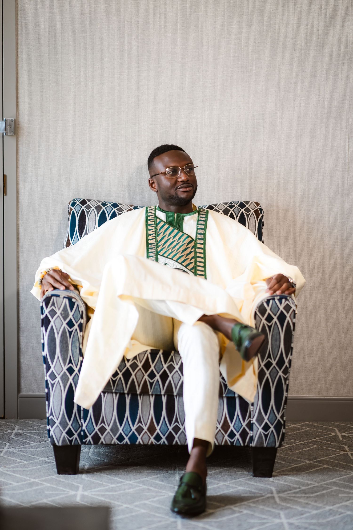 A person in a white outfit relaxes in a patterned armchair while showing different casual poses.