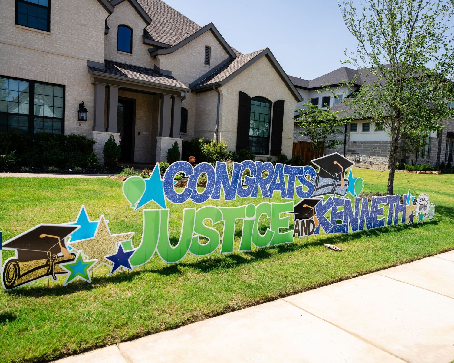 A long graffiti mural spans across a retaining wall next to residential homes with colorful text and star designs.