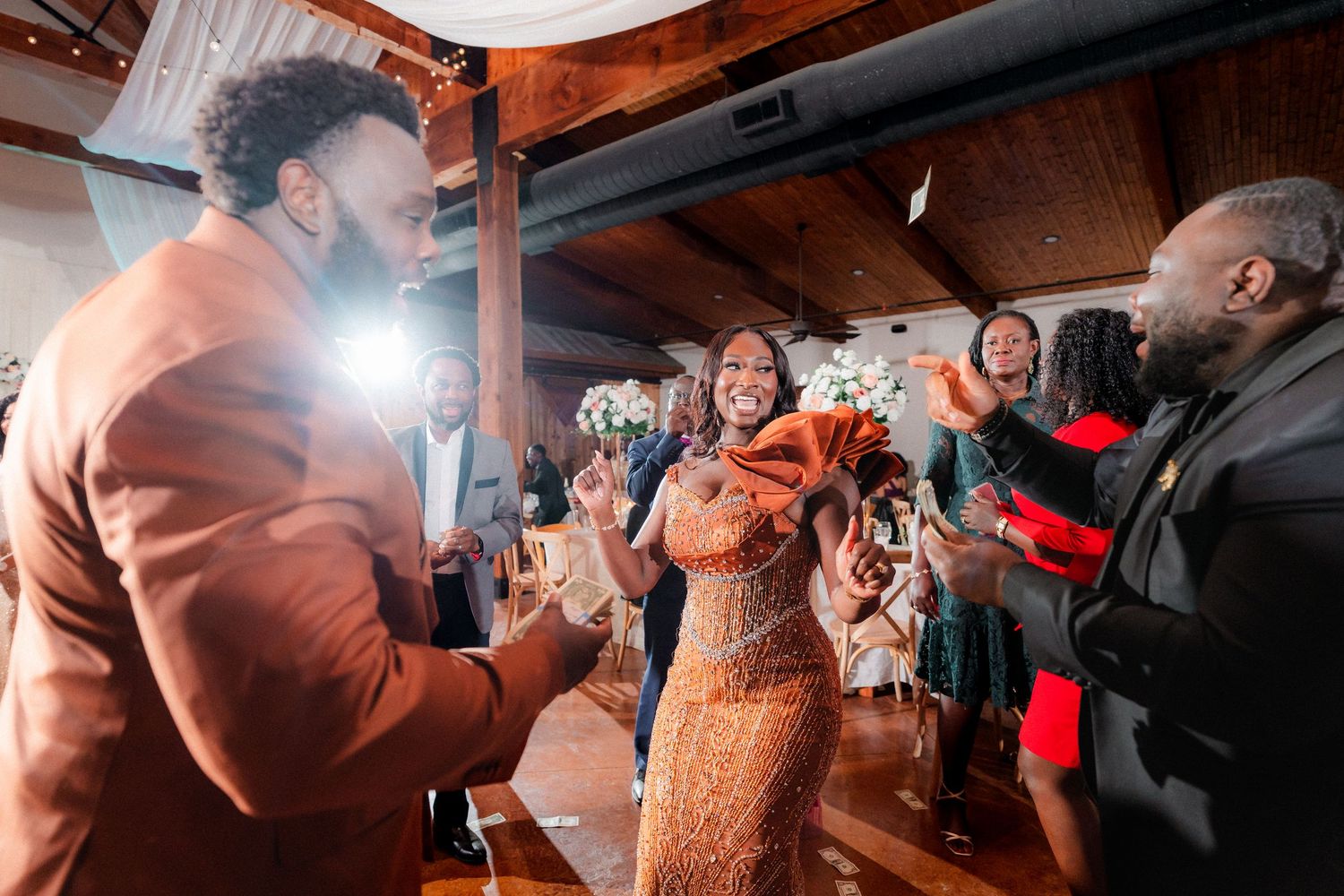 Wedding reception dance floor filled with celebrating guests under dim lighting.