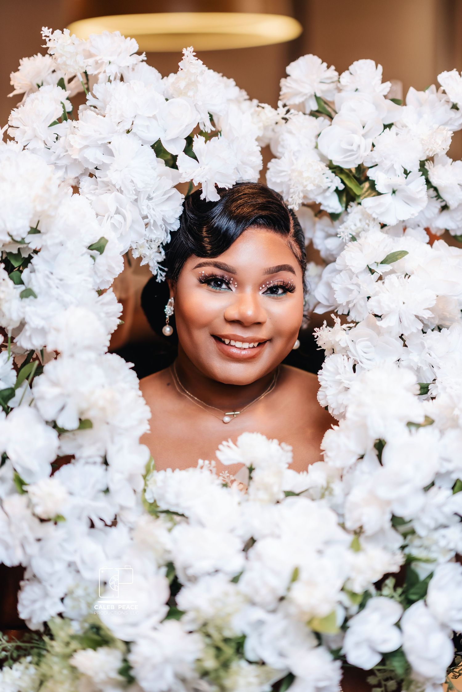 Bridal portrait surrounded by white floral arrangements creating a romantic frame.