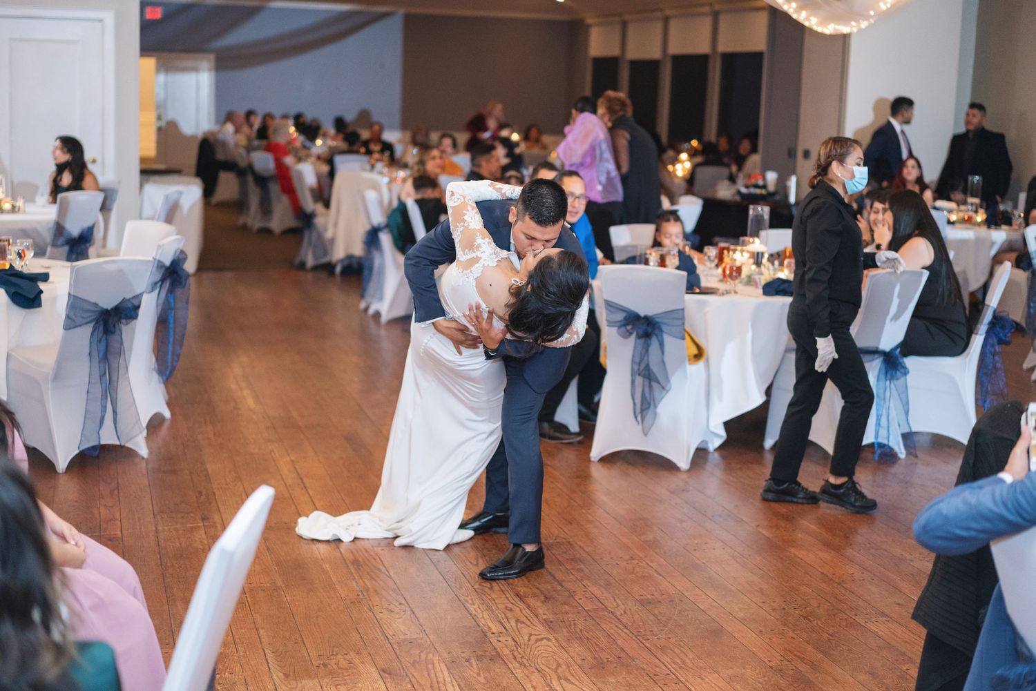 Wedding reception venue with guests dancing and mingling on dance floor.