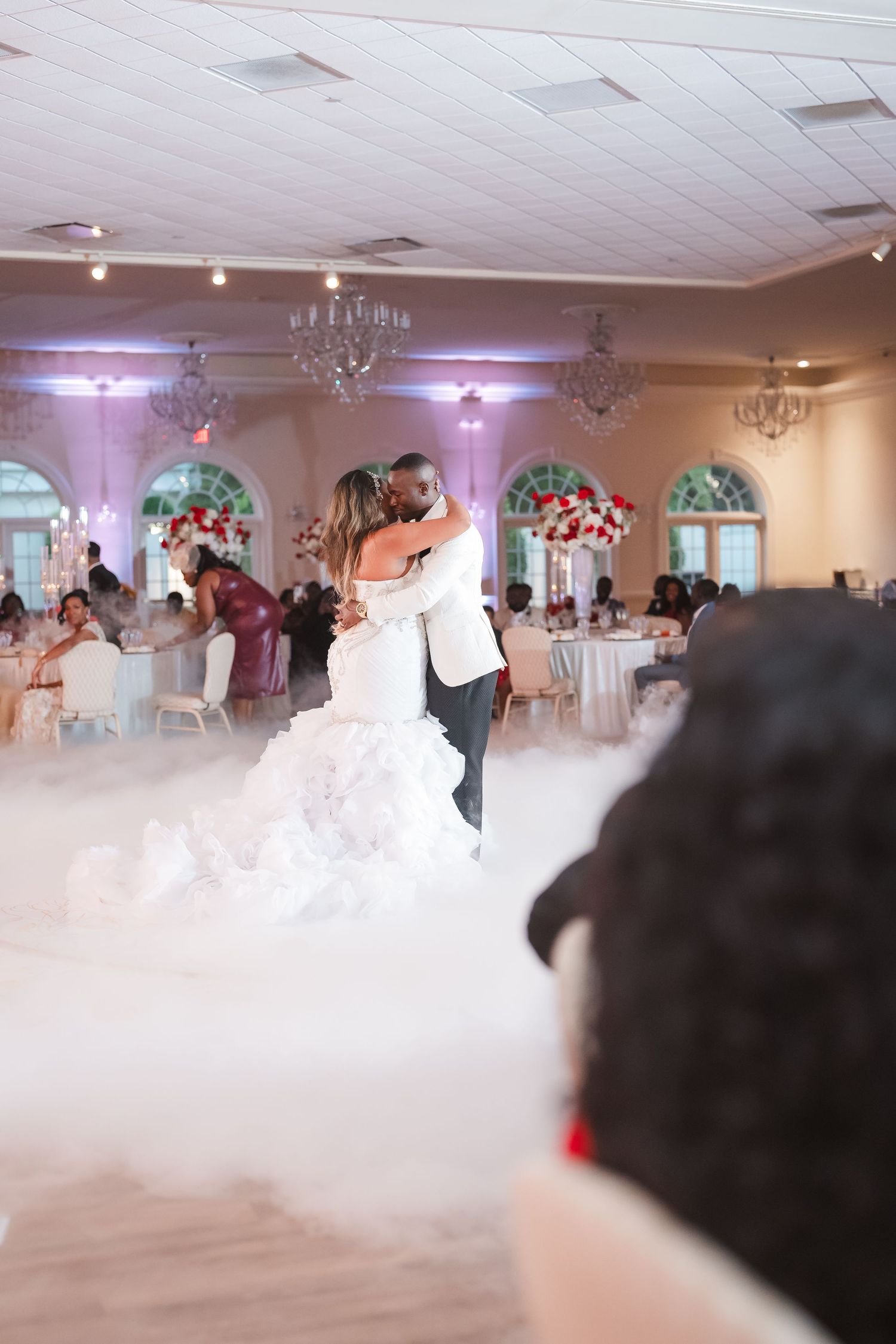 Wedding reception venue filled with dramatic low-lying fog effect on the dance floor.