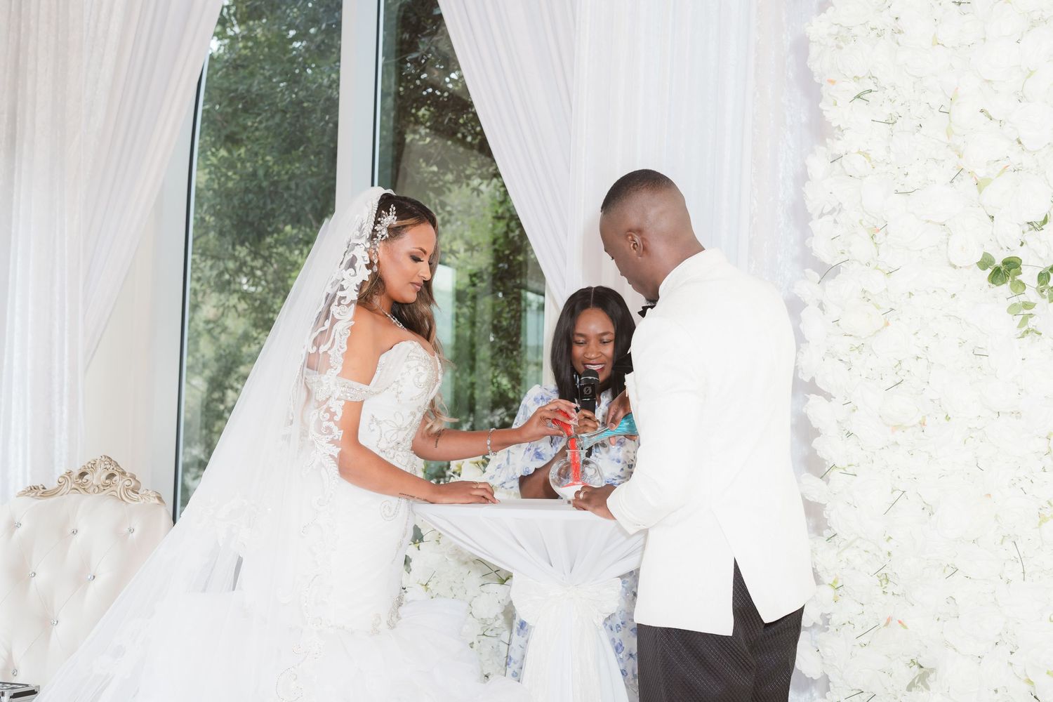 Elegant wedding ceremony setting with white drapes and floral decorations creating a romantic atmosphere.