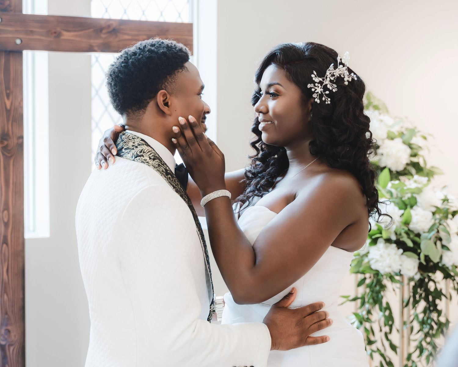 Romantic wedding couple shares intimate moments during their first dance in an elegant white venue.