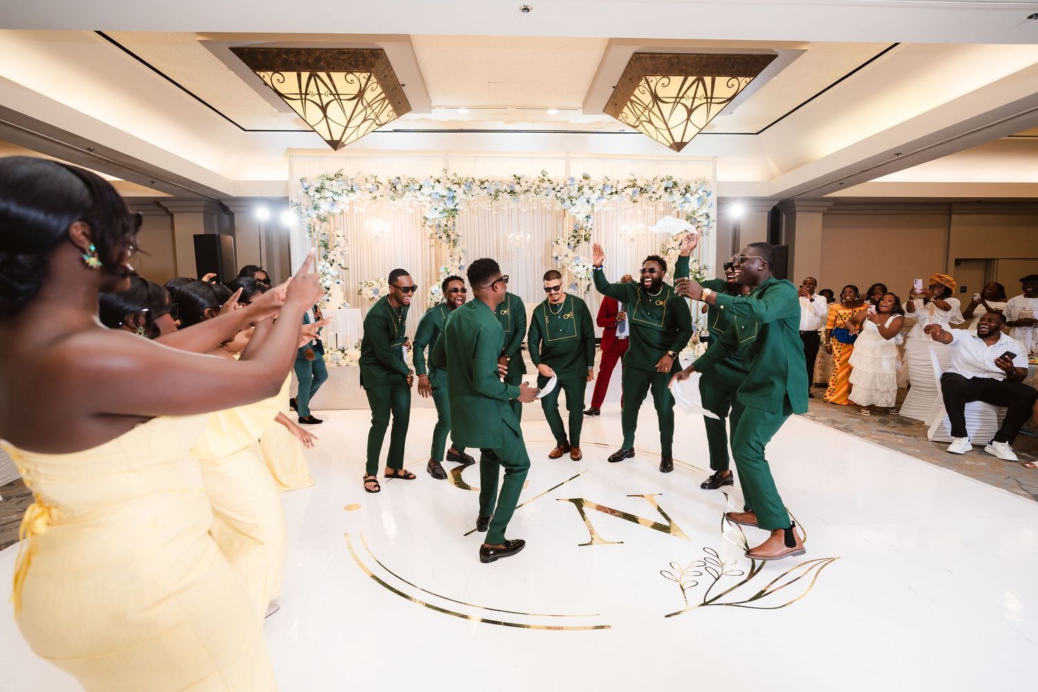 Wedding reception dance floor filled with celebrating guests in formal attire.