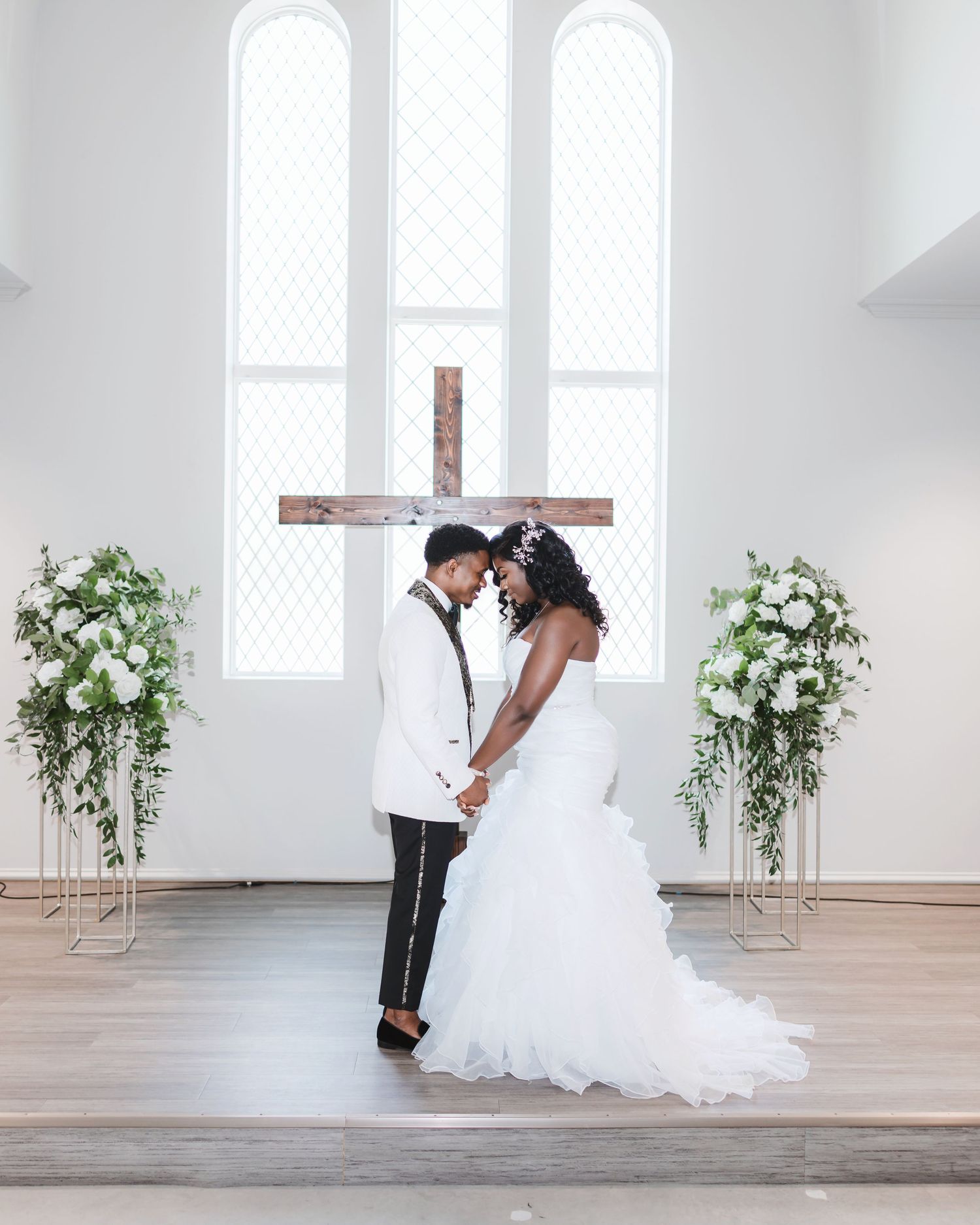 Wedding photoshoot in minimalist white chapel space with natural lighting.