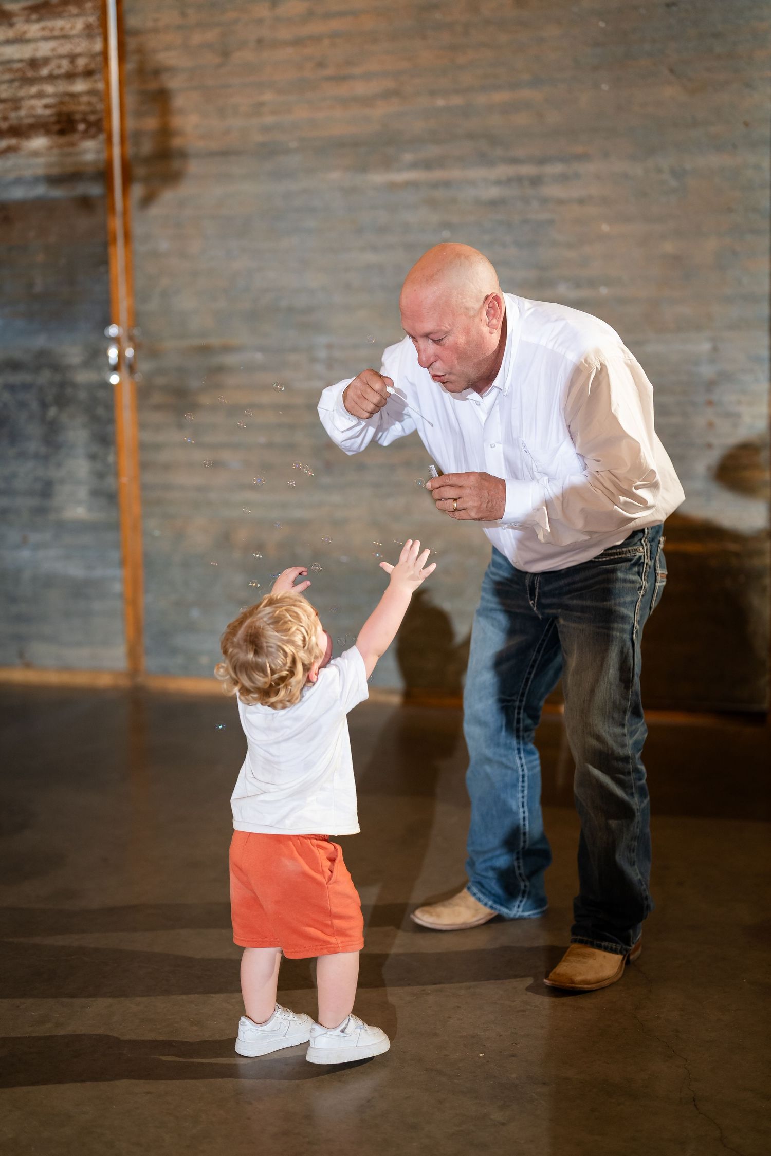 Sweet dance sequence between partners in a rustic indoor venue.