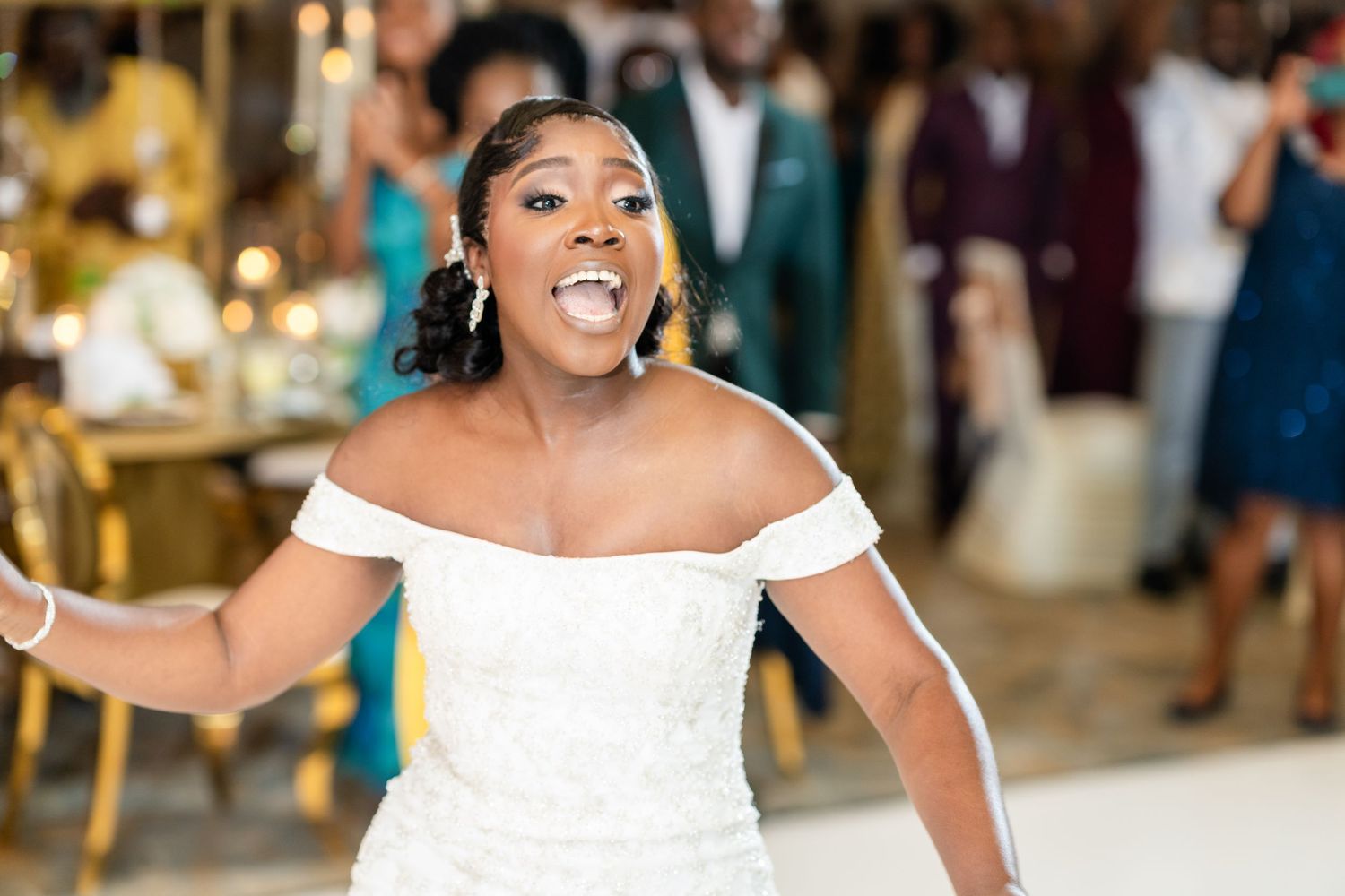 Joyful celebration moment during wedding reception with elegant white decor and guests.