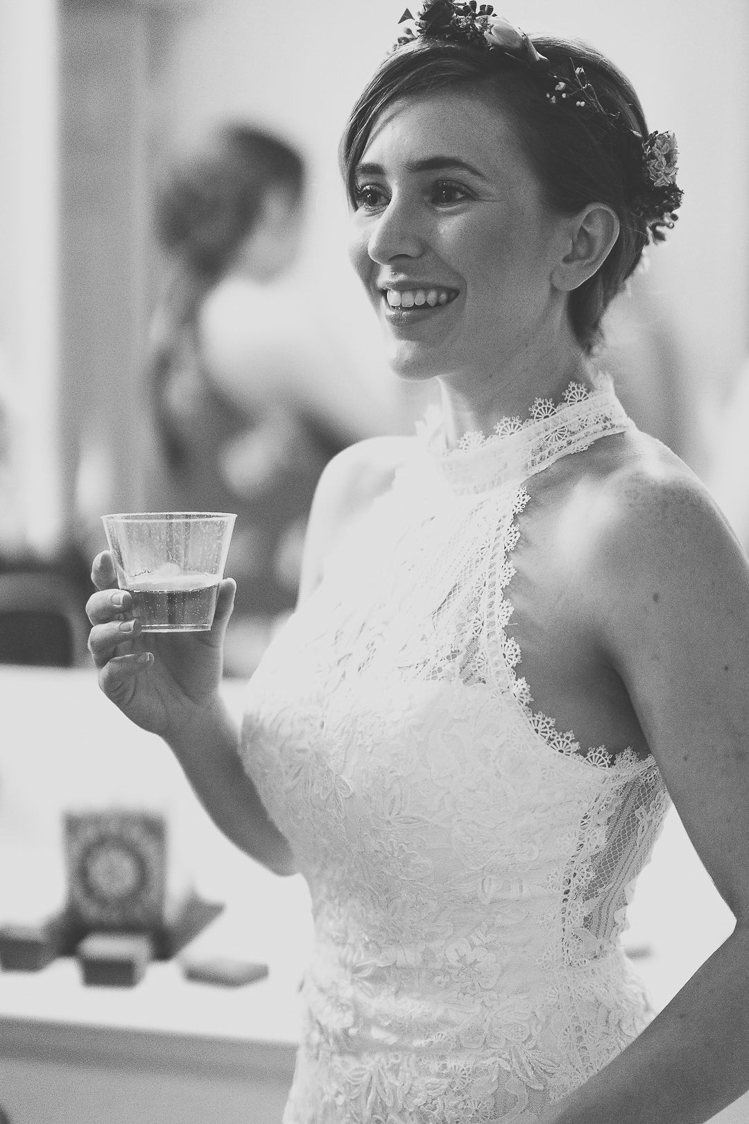Black and white wedding photo series showing bride in lace high-neck gown holding teacup in elegant poses.