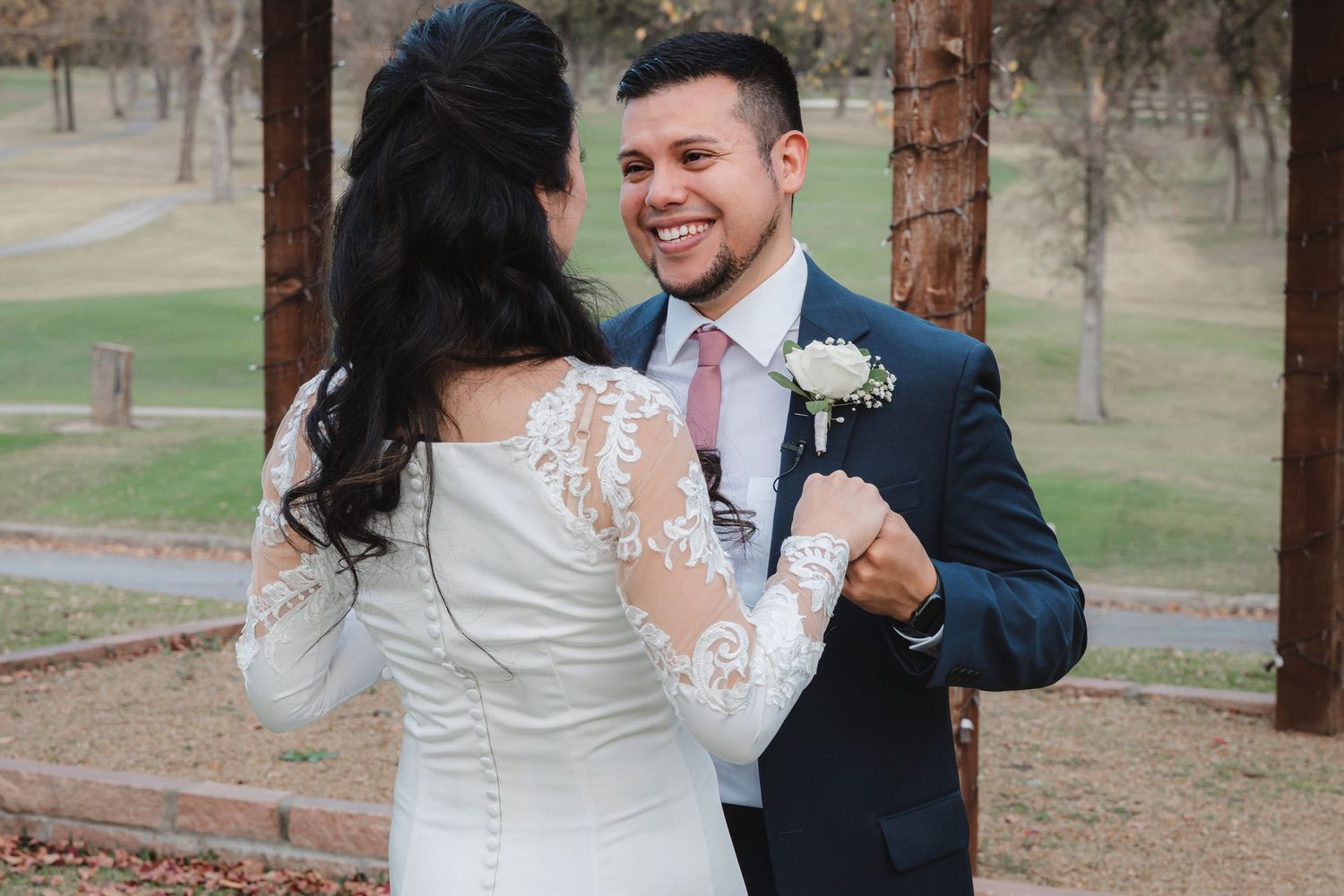 A couple dances together outdoors among autumn trees during their wedding celebration.