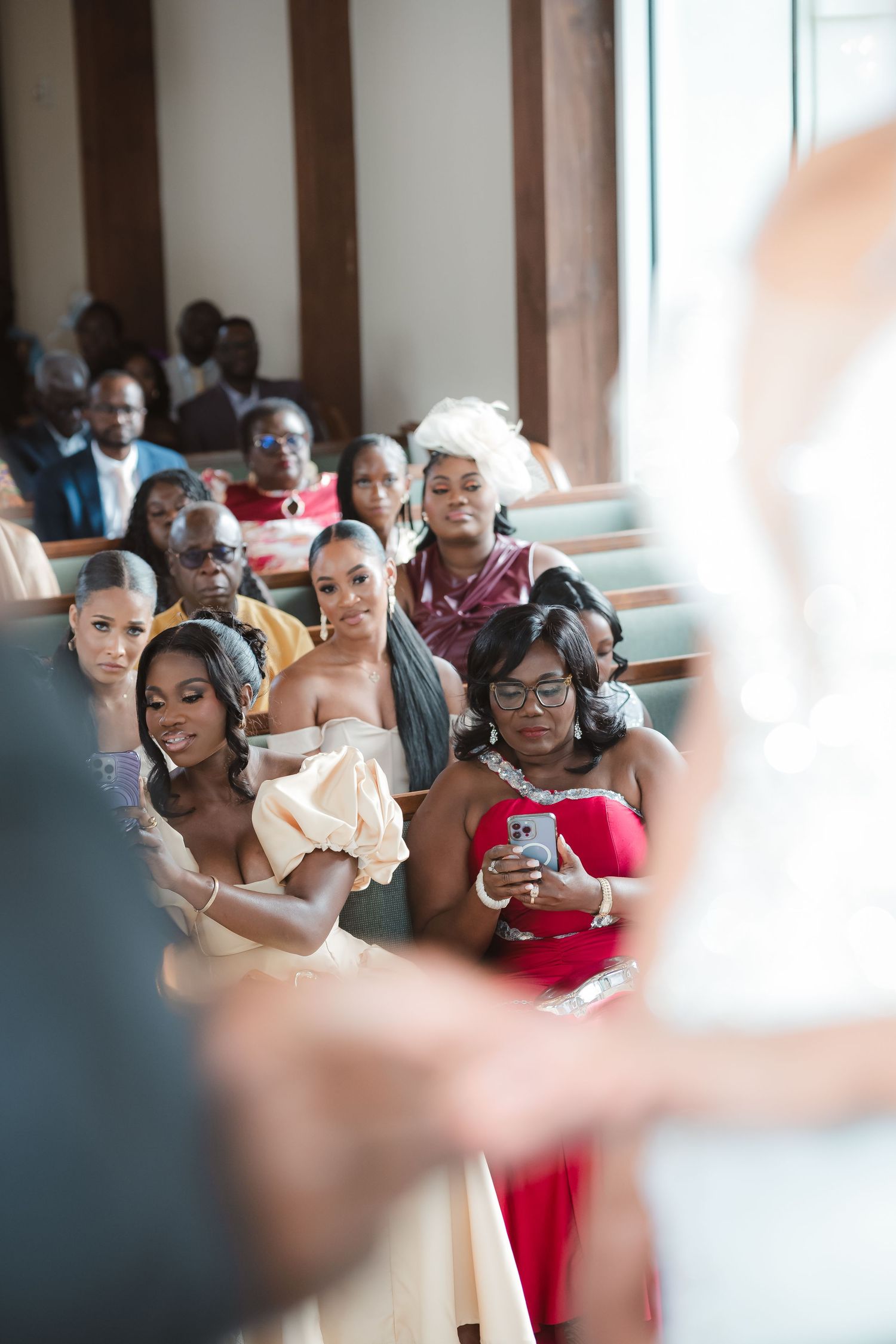 Wedding guests seated in church pews watching the ceremony proceedings.