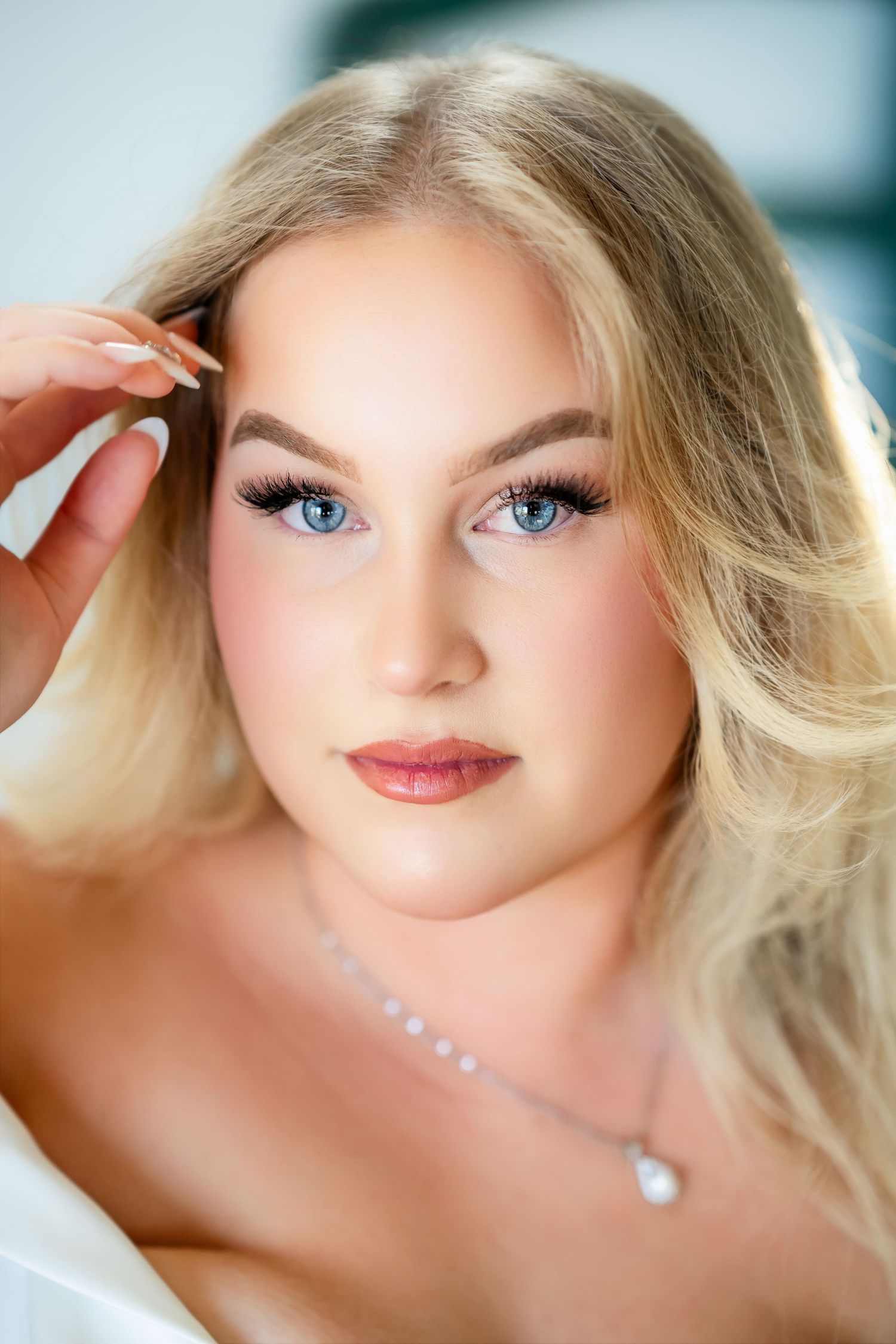 Close-up beauty shots of a bride with blonde hair and blue eyes wearing natural makeup.