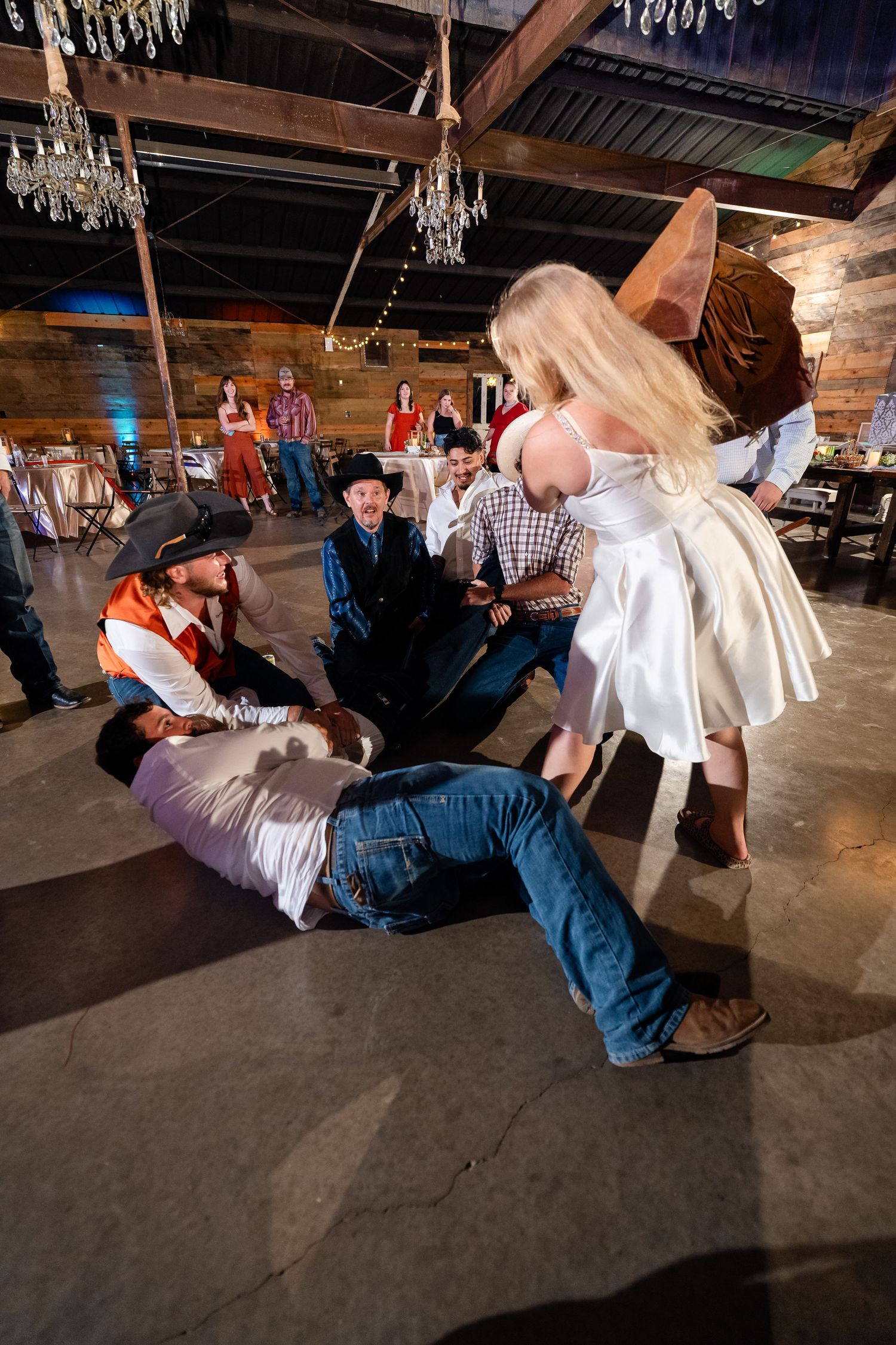 Dynamic dance sequence in a rustic venue with chandeliers showing a dramatic dip move.