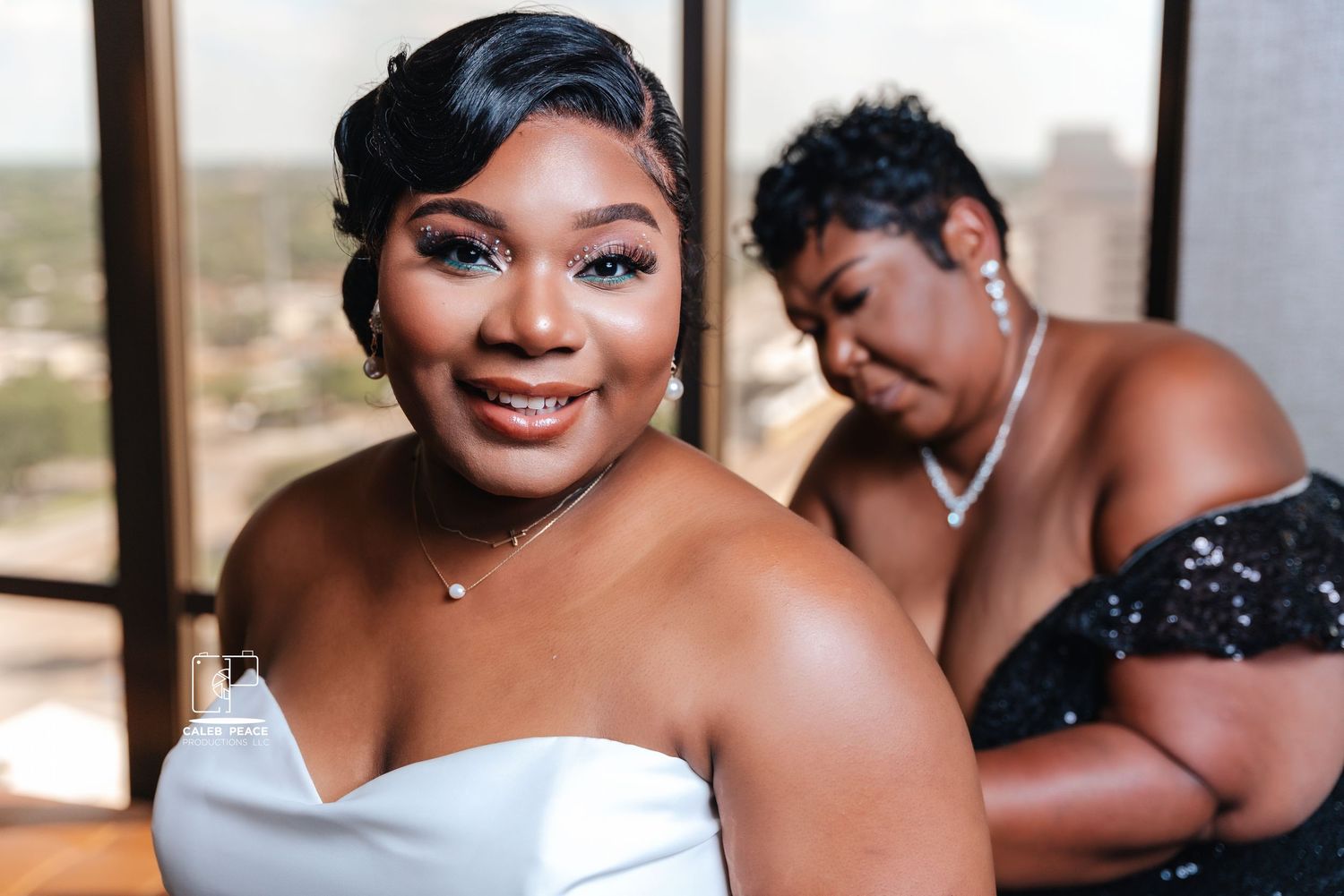 Two people share a candid moment while getting ready in formal attire.