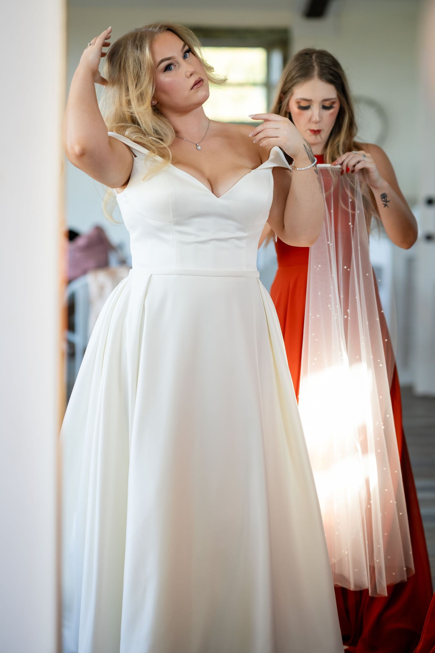 Close-up details of a white wedding dress being fitted.