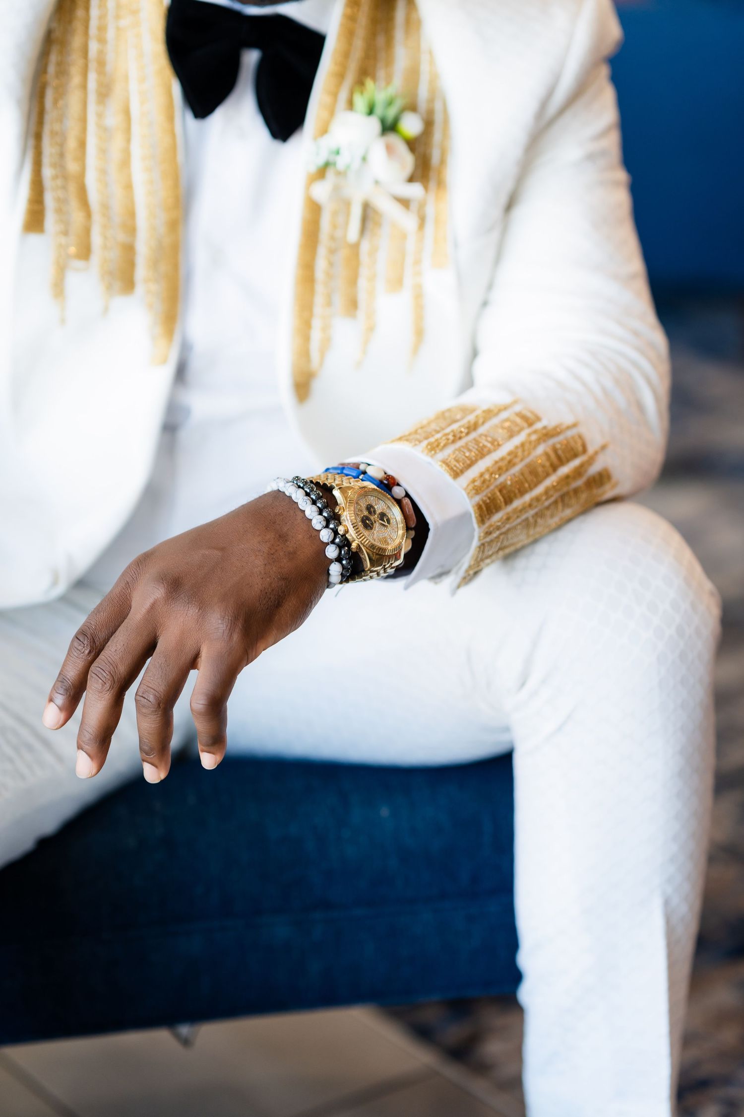 Close-up details of white formal attire and accessories against a dark background.