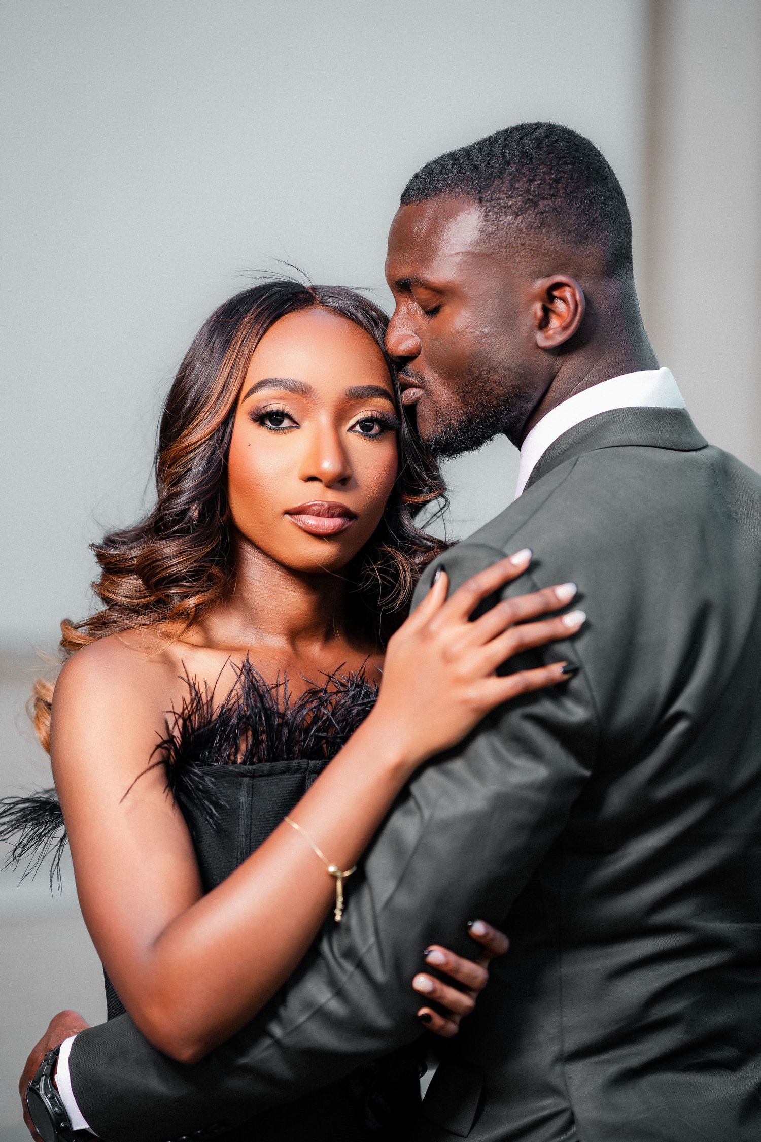 Intimate engagement photos showing couple in black dress and grey suit.