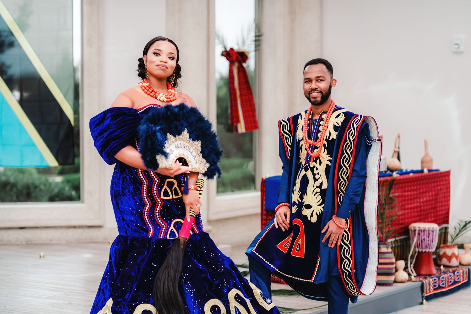 Wedding party wearing traditional attire in blue and red colors poses together for formal portraits.