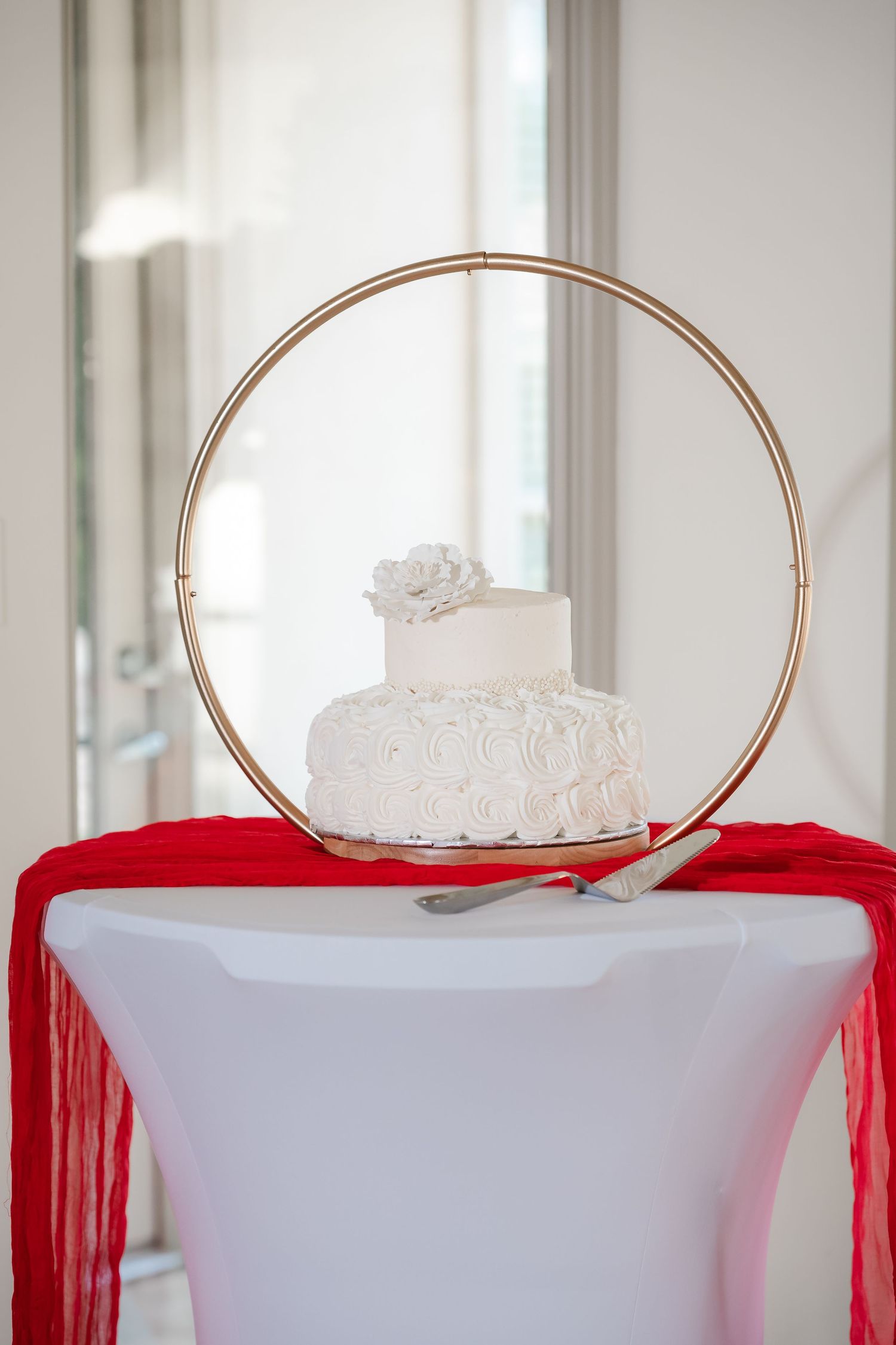 Wedding cake display with gold circular stands and red accent decor.