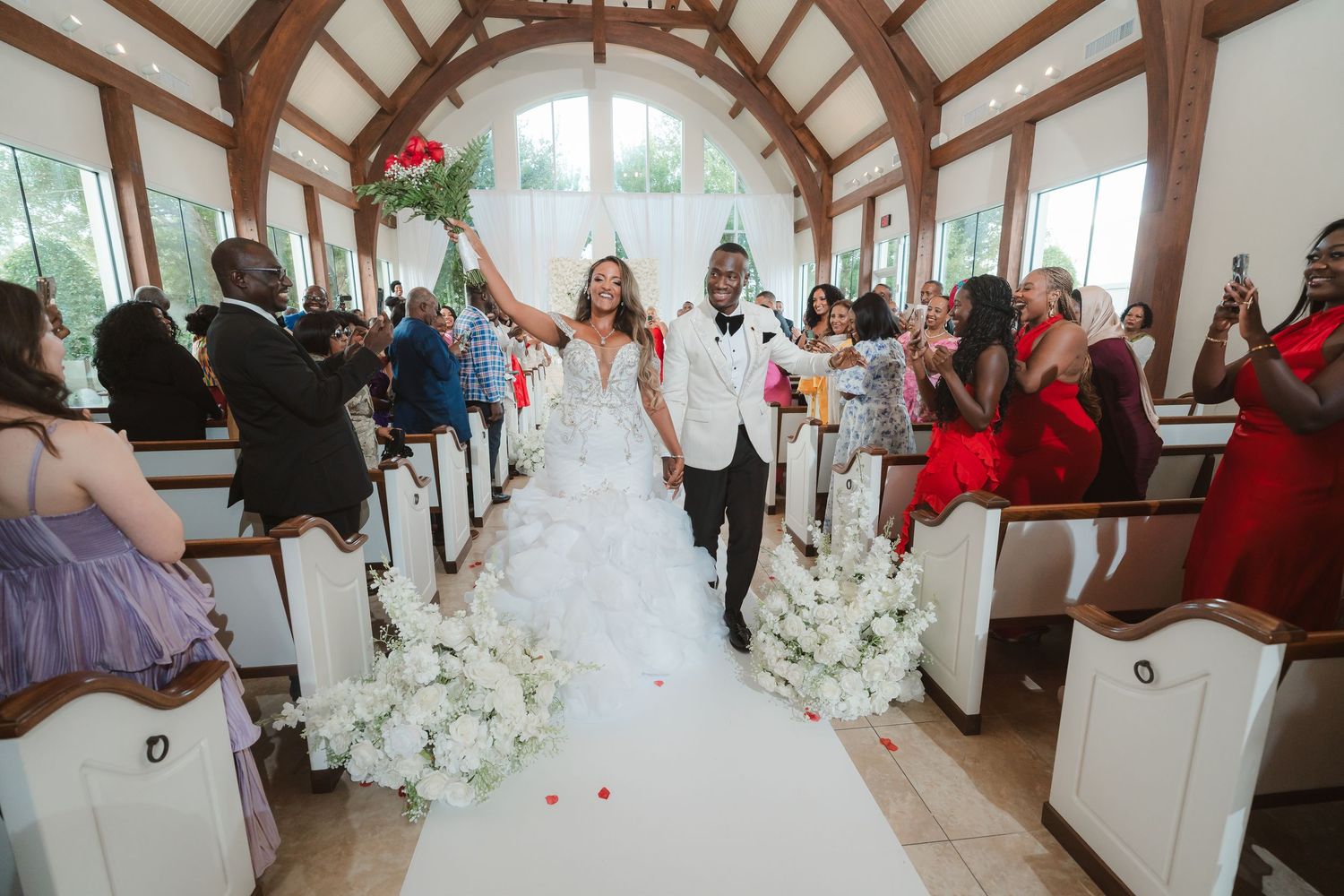 Wedding celebration in an elegant venue with exposed wooden beams and white decor.