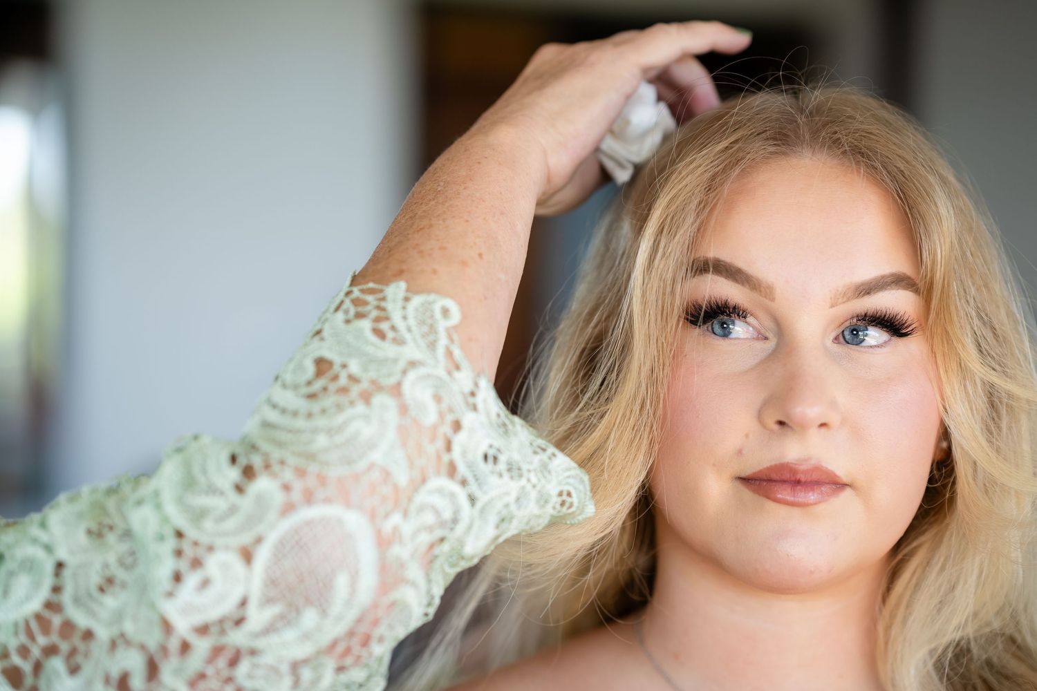 Close-up bridal portrait with elegant makeup and soft lighting.