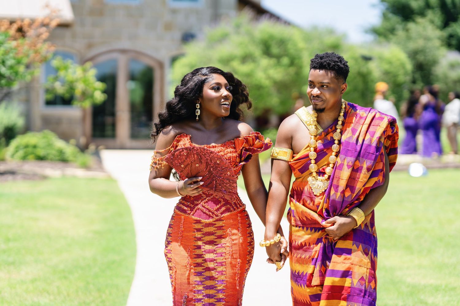 Wedding celebration outdoors with colorful traditional African attire and joyful dancing.