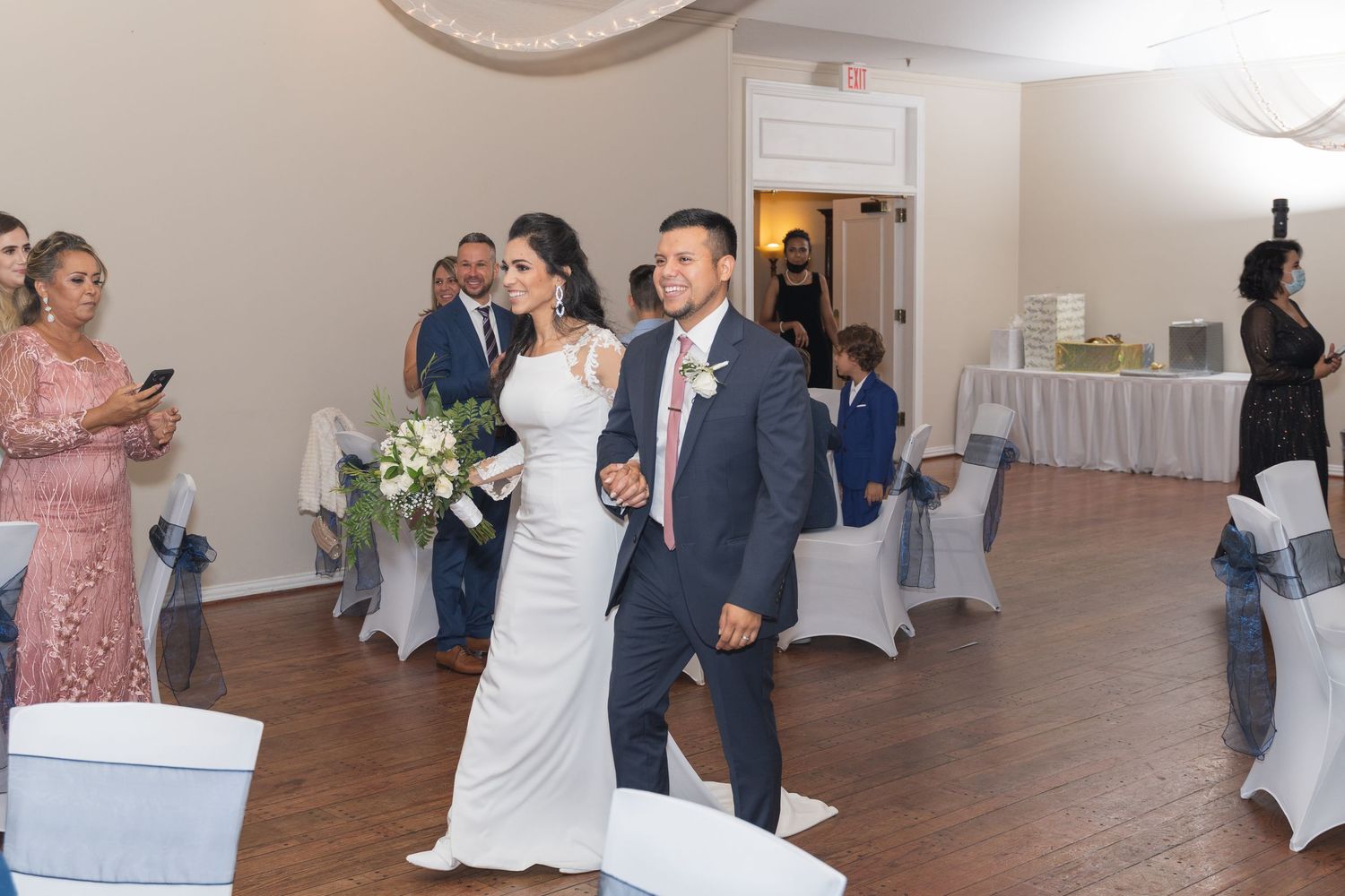Wedding reception venue with white chairs and modern decor setup for celebration.
