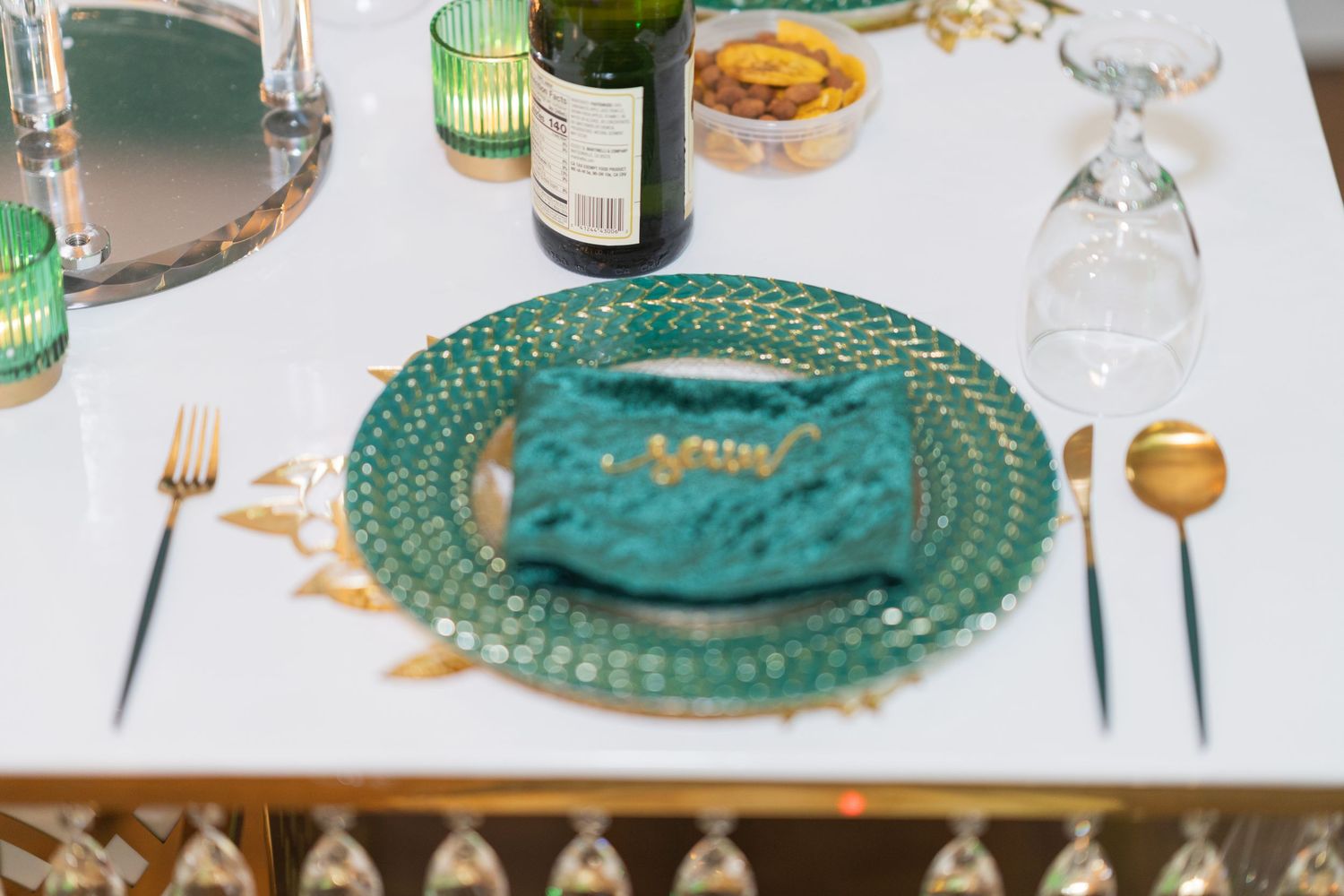 Elegant table setting with teal charger plates and wine glasses for a formal wedding reception.