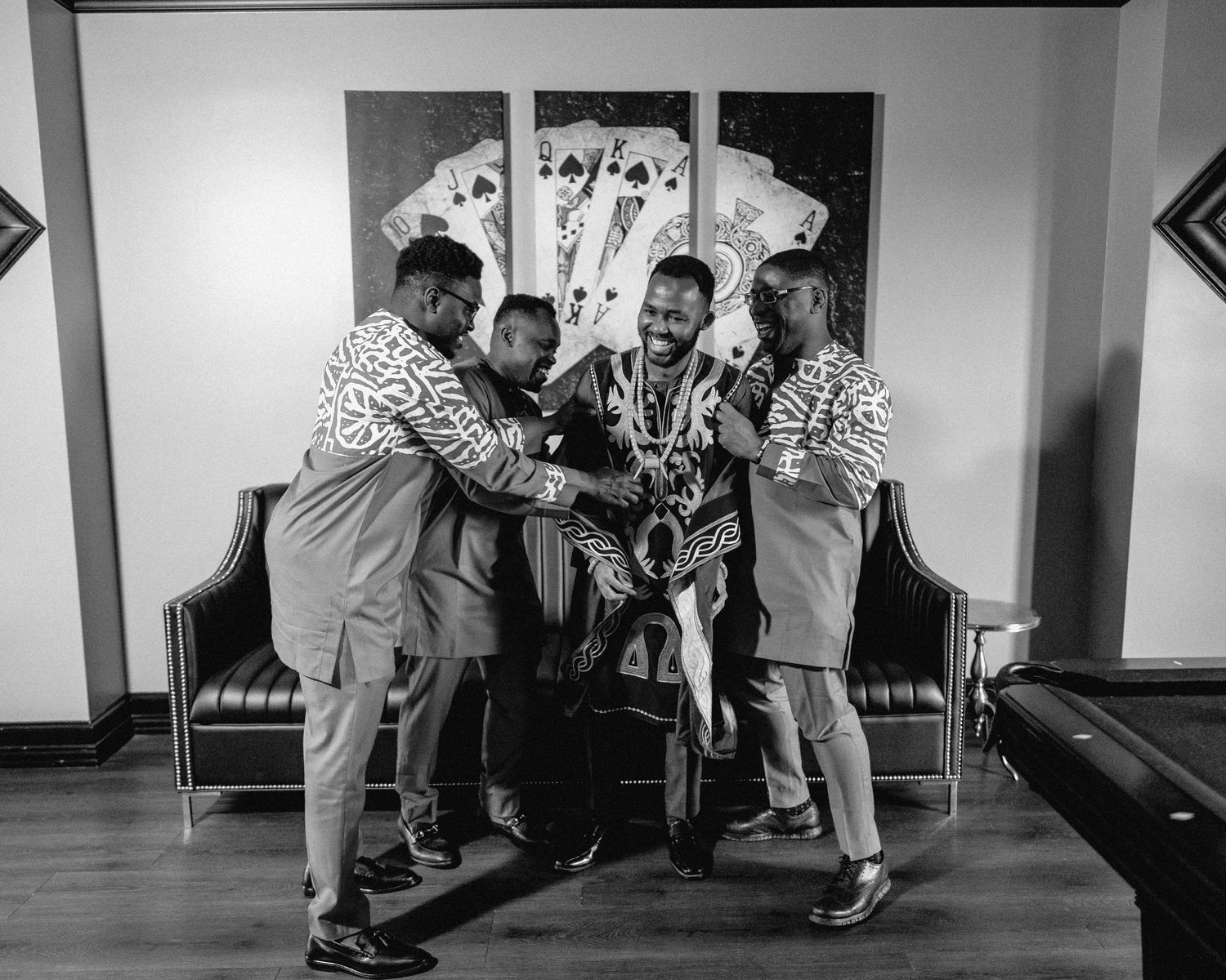 Black and white photo of dancers performing traditional dance moves on a wooden floor.