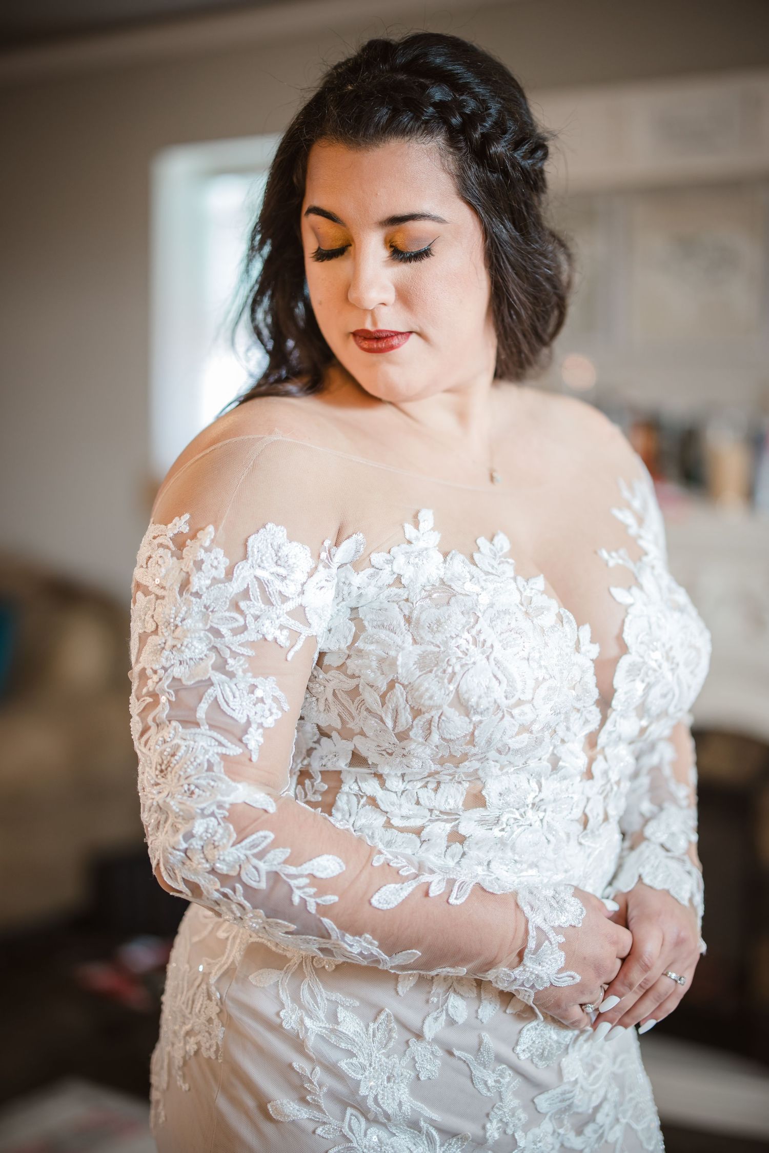 Close-up details of a delicate white lace wedding dress with sheer sleeves and floral appliques.