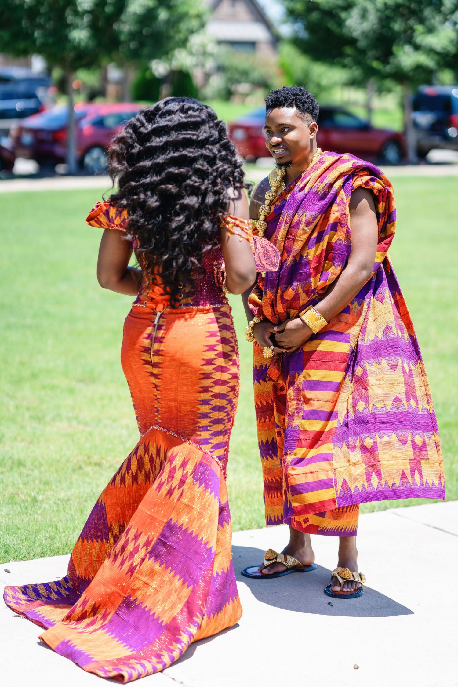 Series of outdoor photos showing vibrant orange and purple traditional African kente print dress.