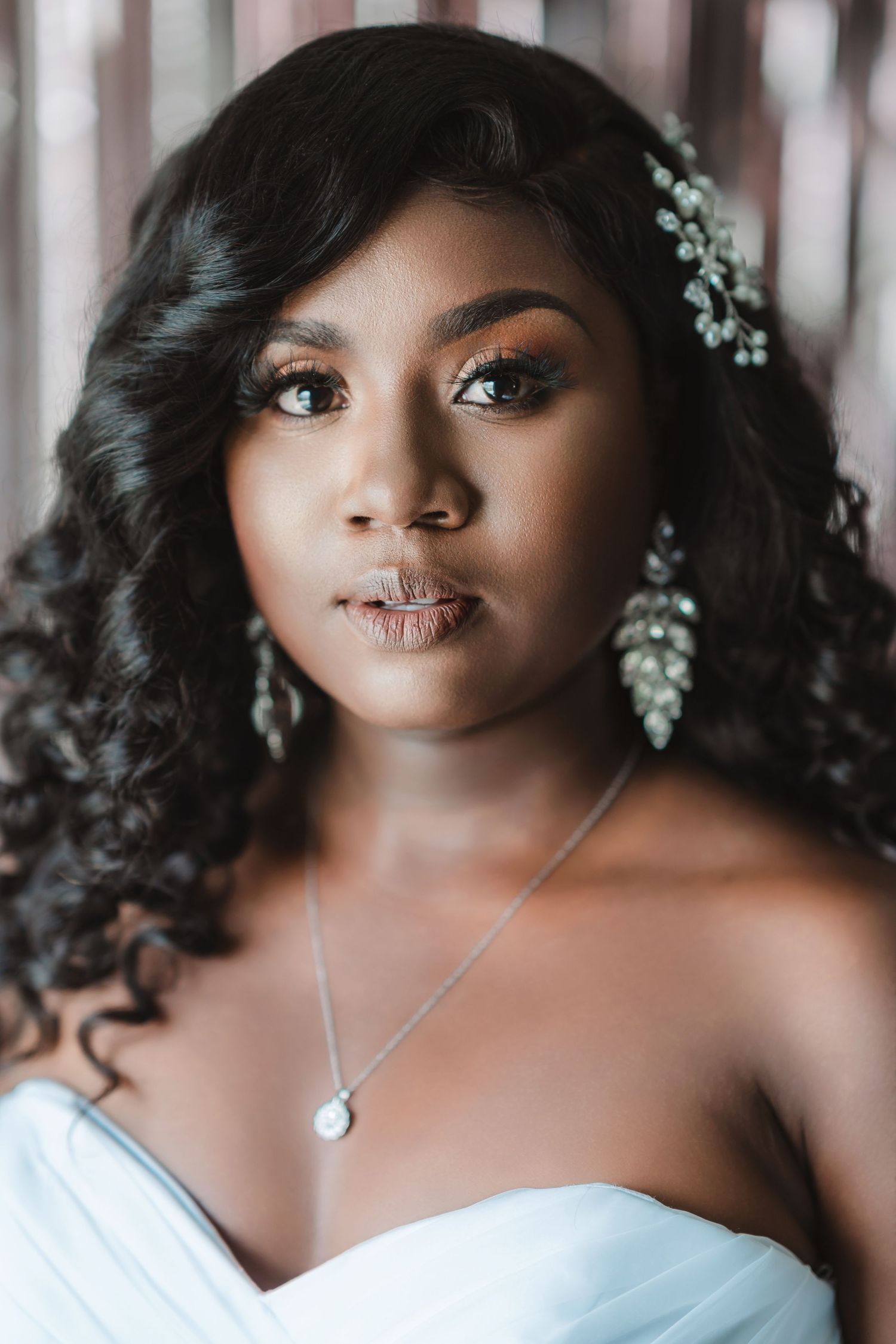 Close up bridal portrait showing delicate necklace and soft makeup.