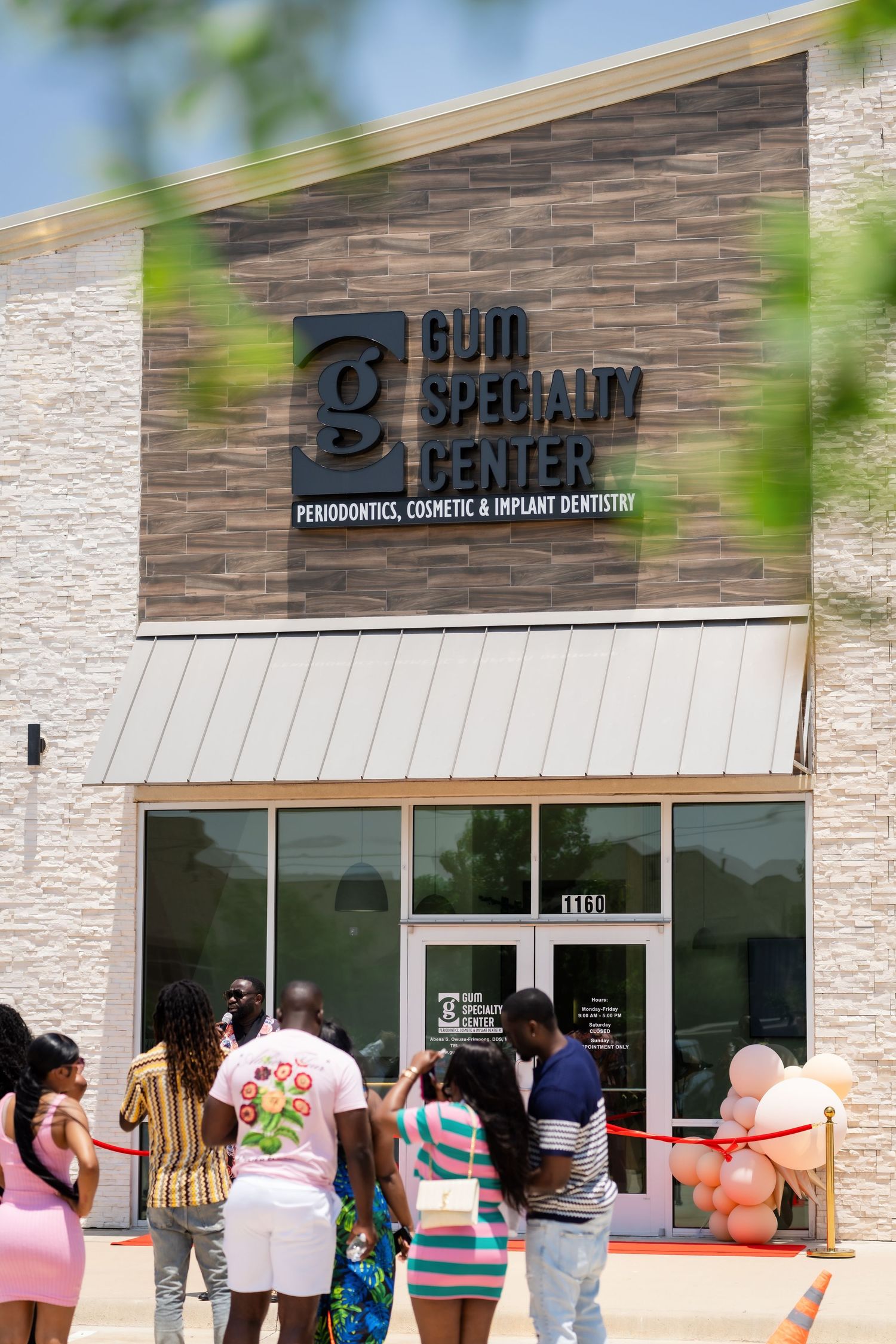 People waiting in line outside a Bell Center storefront with stone facade and glass doors.