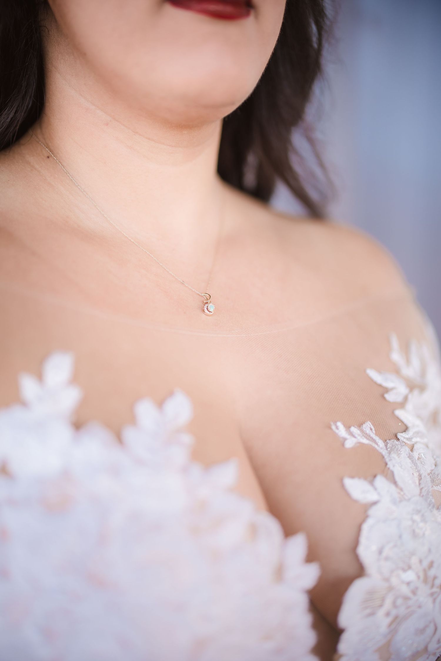 Artistic detail shot of white lace wedding dress with red lipstick.