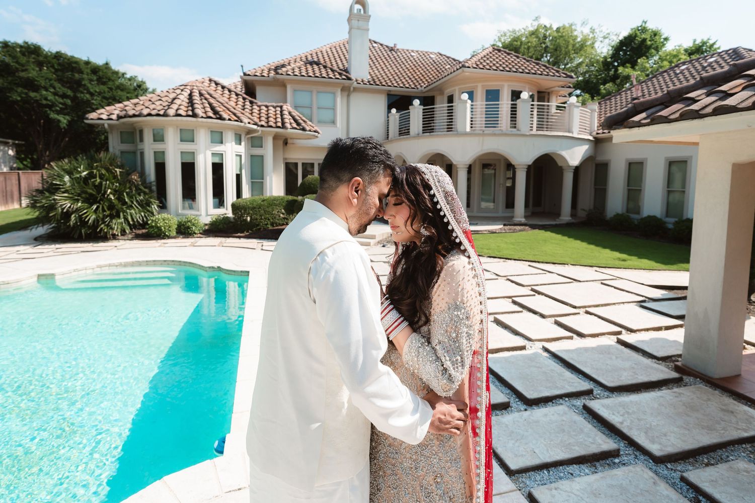 Couple shares romantic moments by a luxurious swimming pool at an upscale venue.