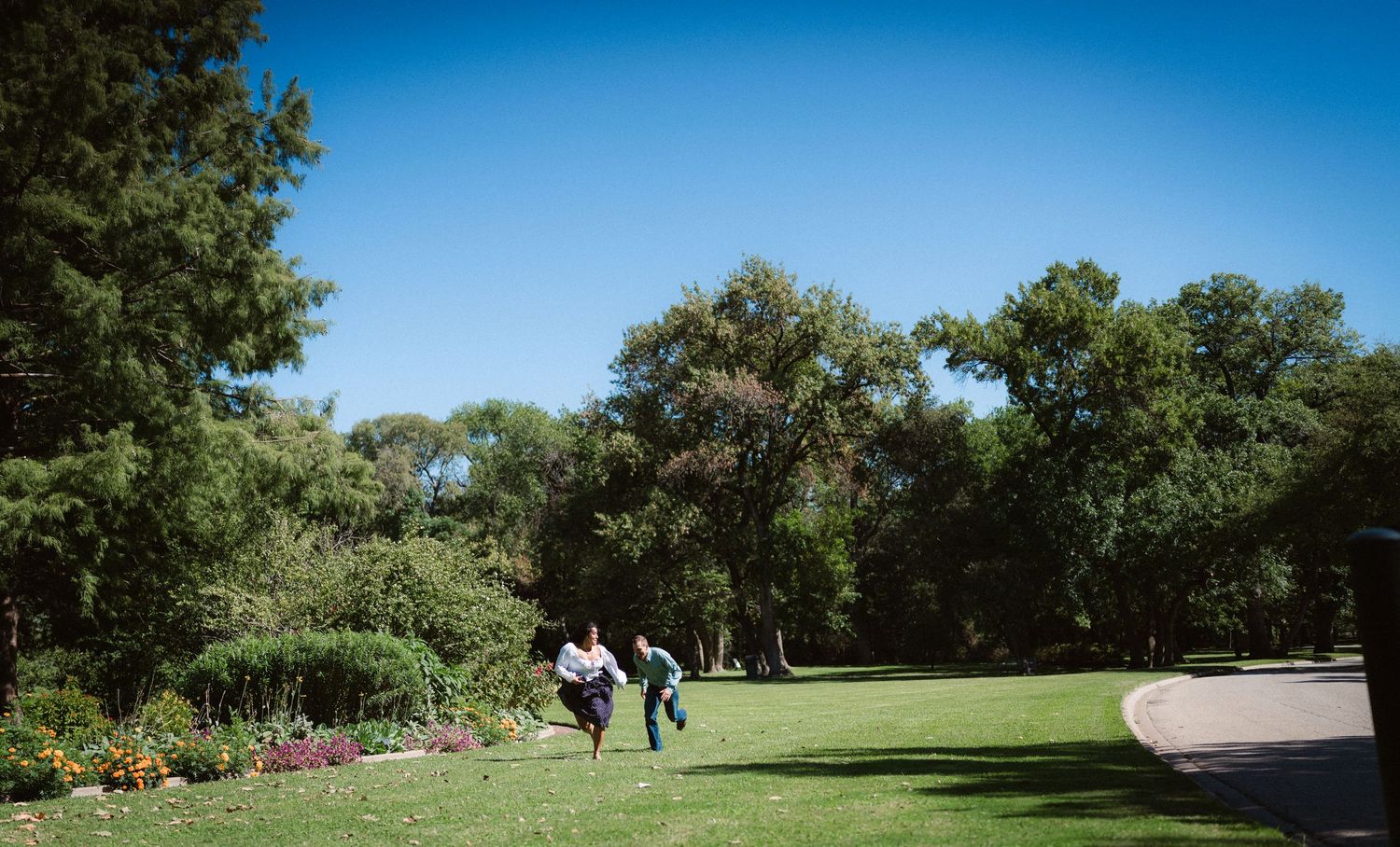 Scenic garden path with green trees and blue sky creating a peaceful outdoor setting.