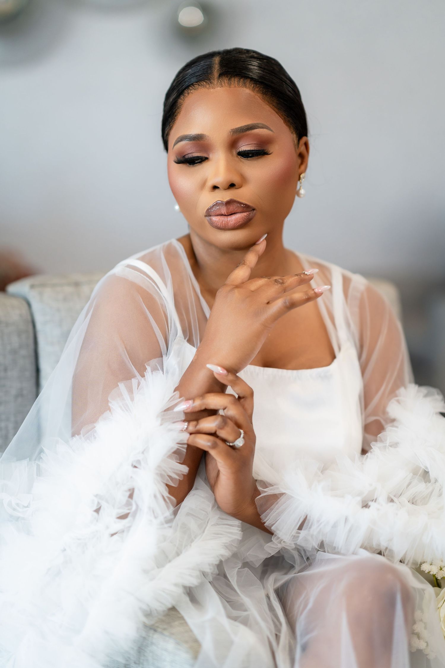 Artistic bridal portraits featuring a romantic white tulle robe against a neutral background.