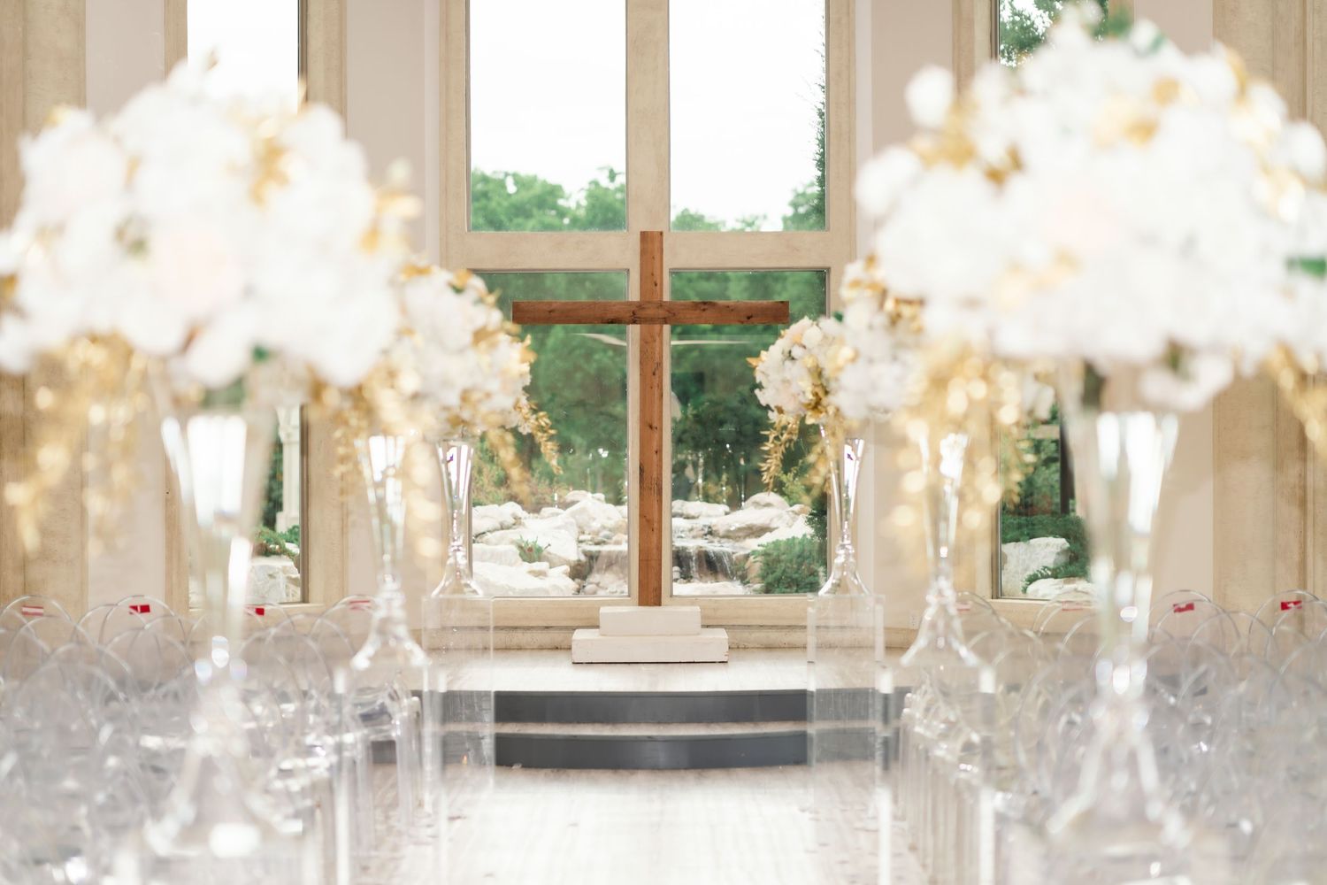 Elegant wedding reception table settings with crystal chandeliers and floral centerpieces in a bright sunlit venue.